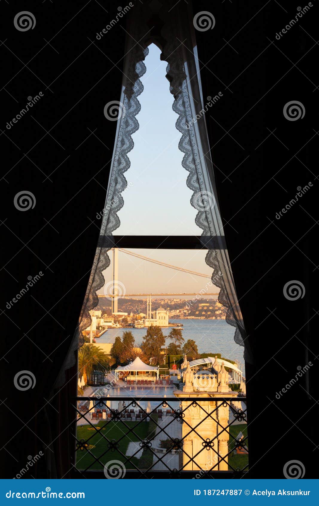 ortakoy buyuk mecidiye mosque and 15 temmuz sehitler bogazici bridge through a window with lace curtains