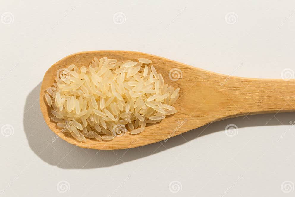 Parboiled Chinese Rice Seed. Nutritious Grains on a Wooden Spoon Stock