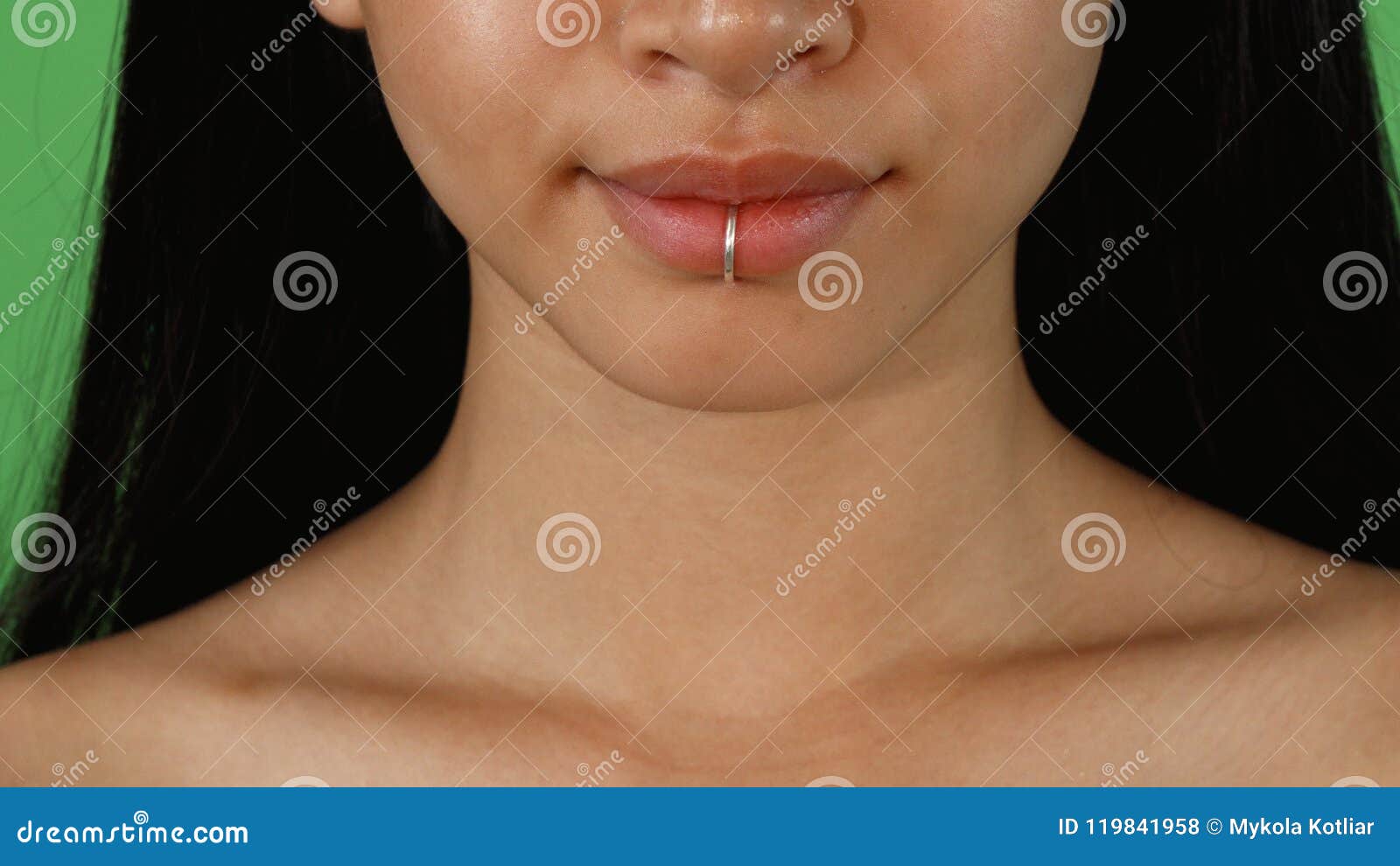 Detalhe de um piercing labret na boca de uma mulher sorridente