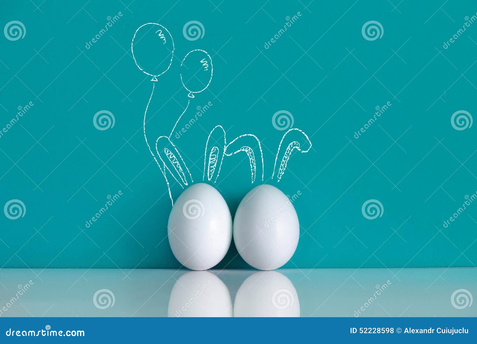 Ostereier gemalt mit den Ohren und den Ballonen auf dem blauen Hintergrund
