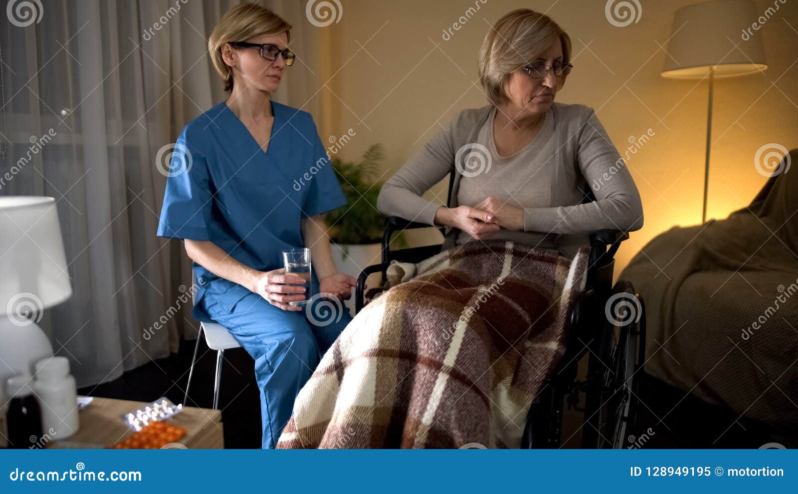 Oude gedeprimeerde dame die geneeskunde van verpleegstershanden weigeren te nemen, het verouderen droefheid, voorraadfoto
