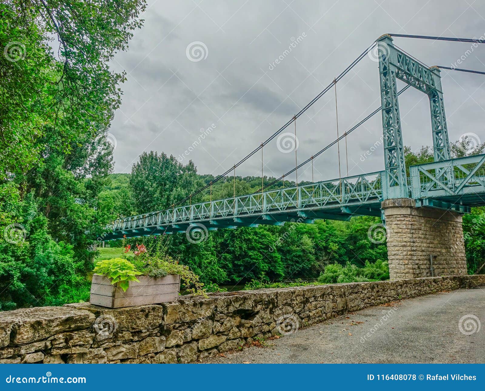 Feneyrols, Midi de Pyreneeën, Frankrijk - Juli 23, 2017: Oude ijzerhangbrug in natuurlijke omgeving op een bewolkte de herfstdag