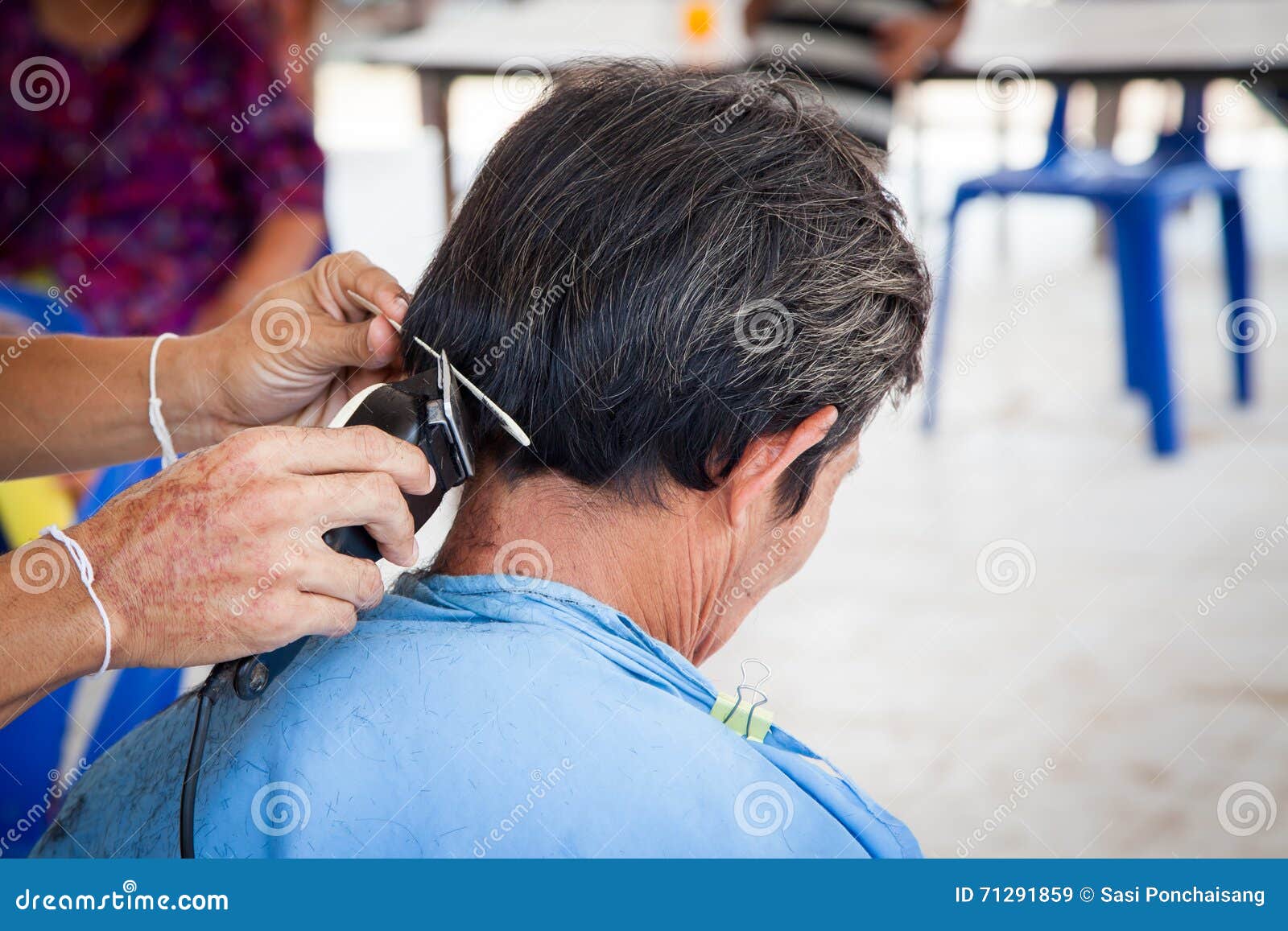 Oude mens die een kapsel met een haarclippers hebben in kapperswinkel