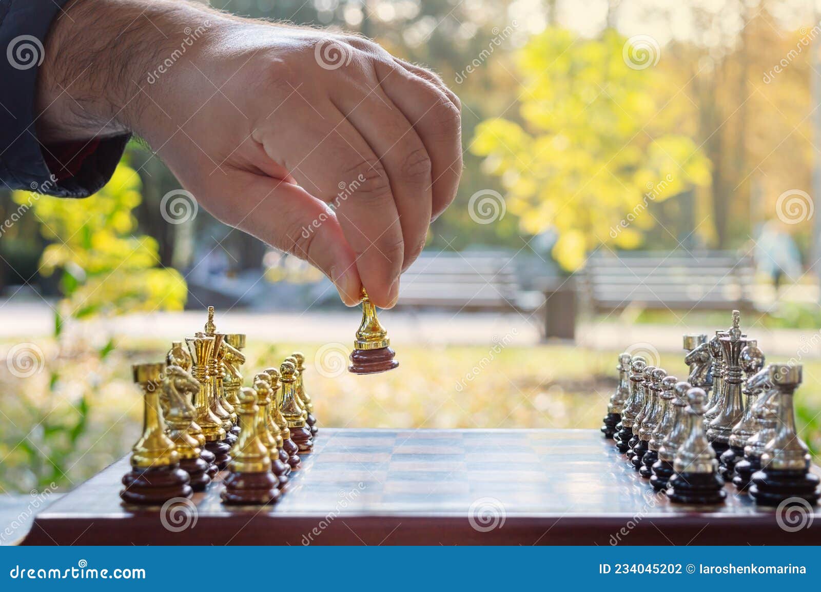 Hand Of A Man Taking A Chess Piece To Make The Next Move In A Chess Game.  Close Up. Spring Day Outside. Stock Photo, Picture and Royalty Free Image.  Image 198493640.