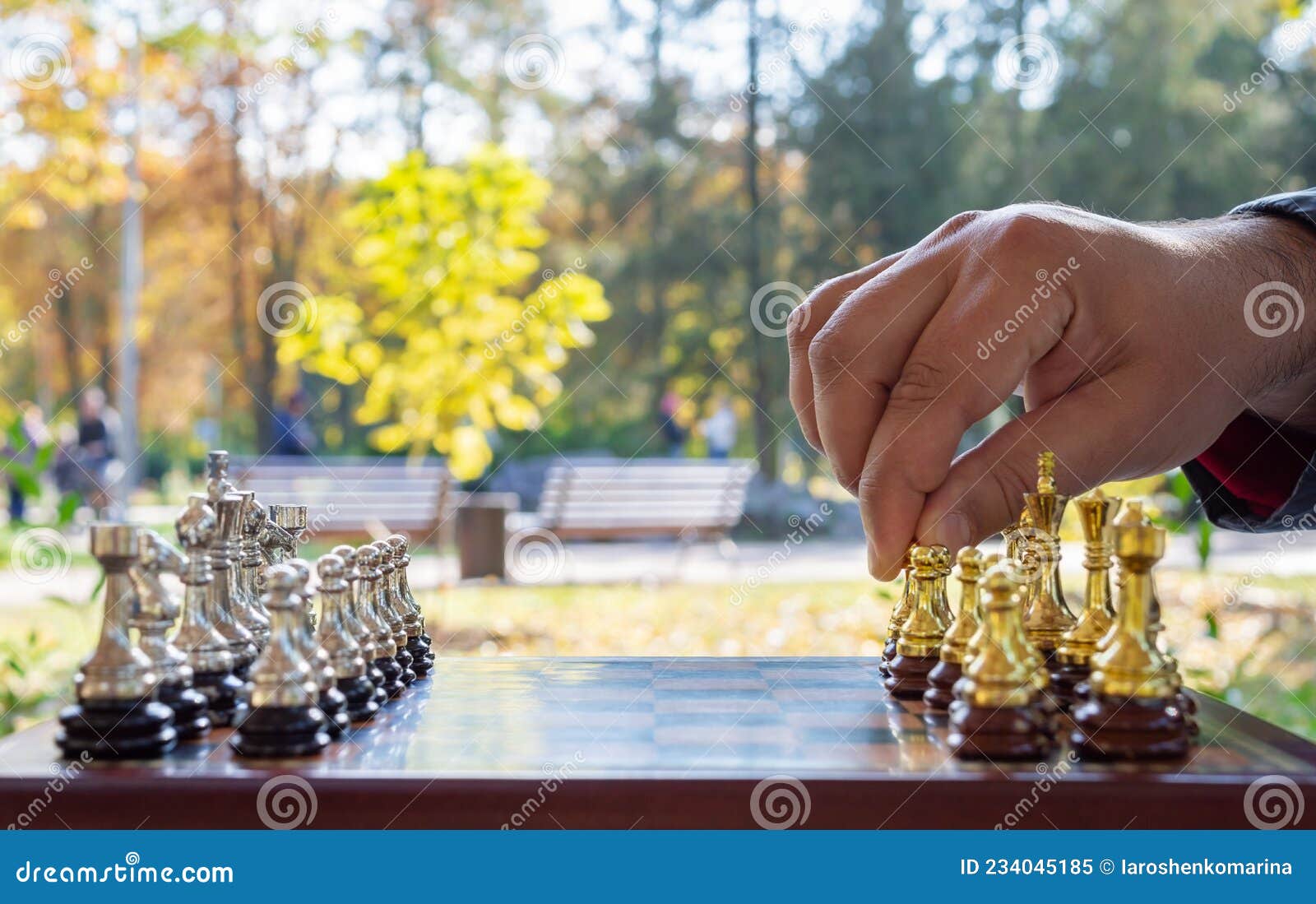 Hand Of A Man Taking A Chess Piece To Make The Next Move In A Chess Game.  Close Up. Spring Day Outside. Stock Photo, Picture and Royalty Free Image.  Image 198493640.