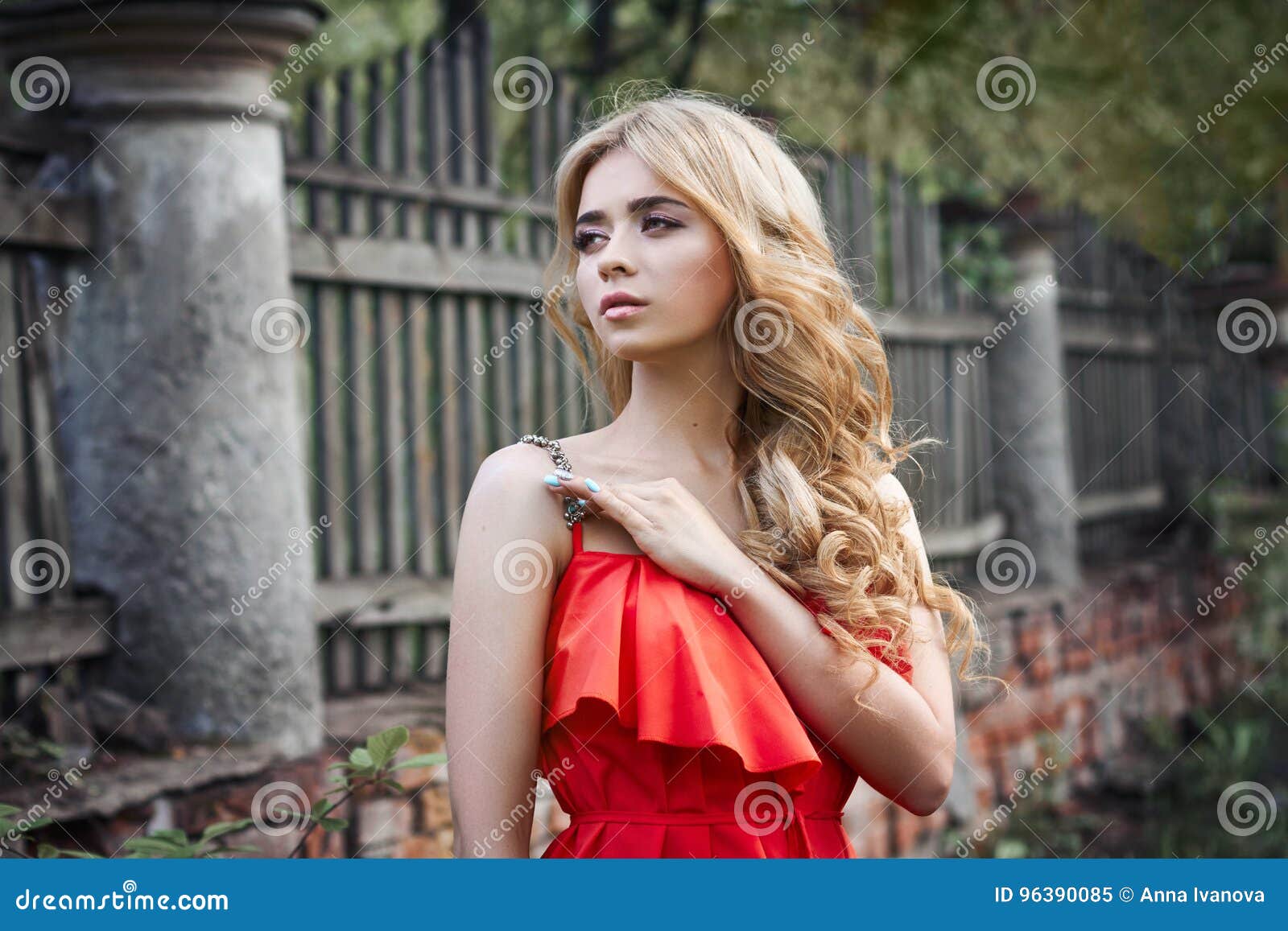 outdoor fashion beautiful young woman photo near old homestead summer. portrait girl blondes in red dress.