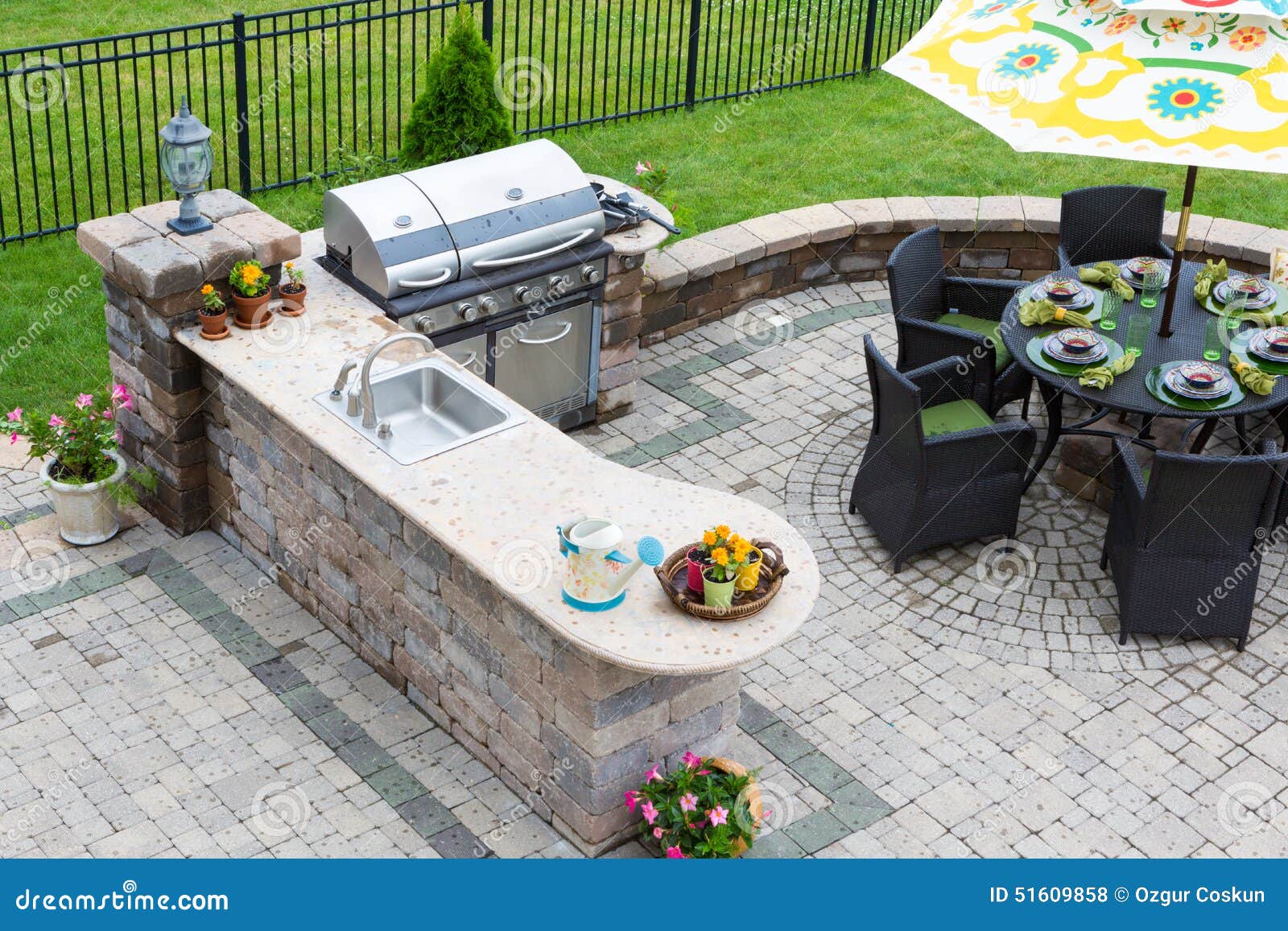 outdoor kitchen and dining table on a paved patio