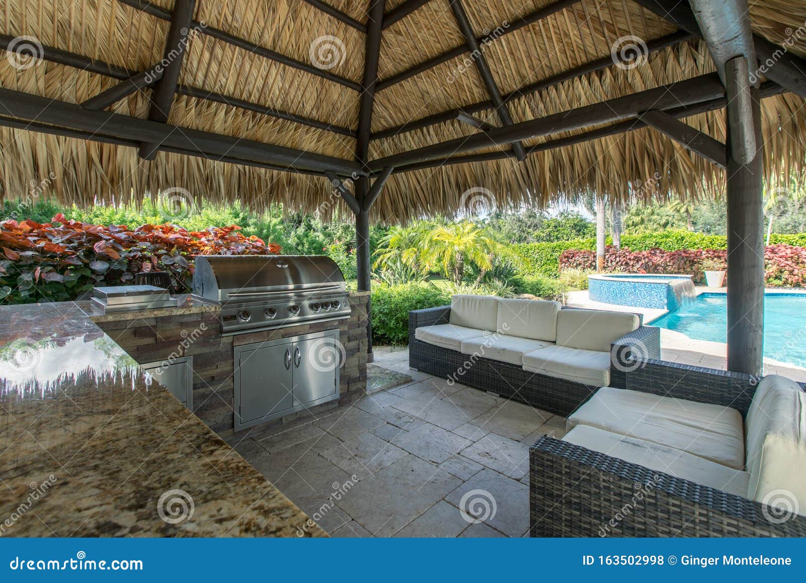outdoor tiki hut with outdoor grill kitchen and pool