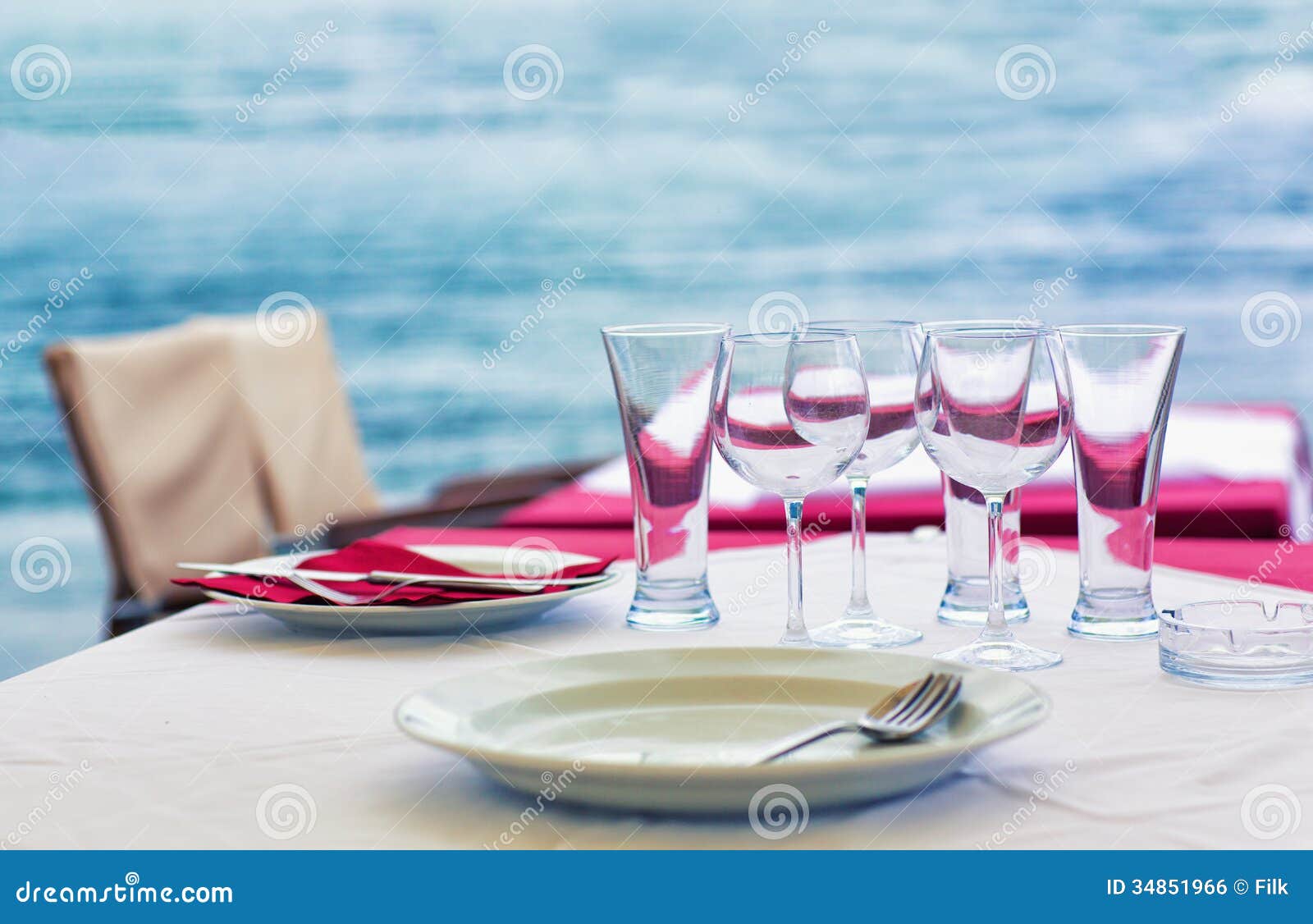 Table at the outdoor sea restaurant, with water on the background