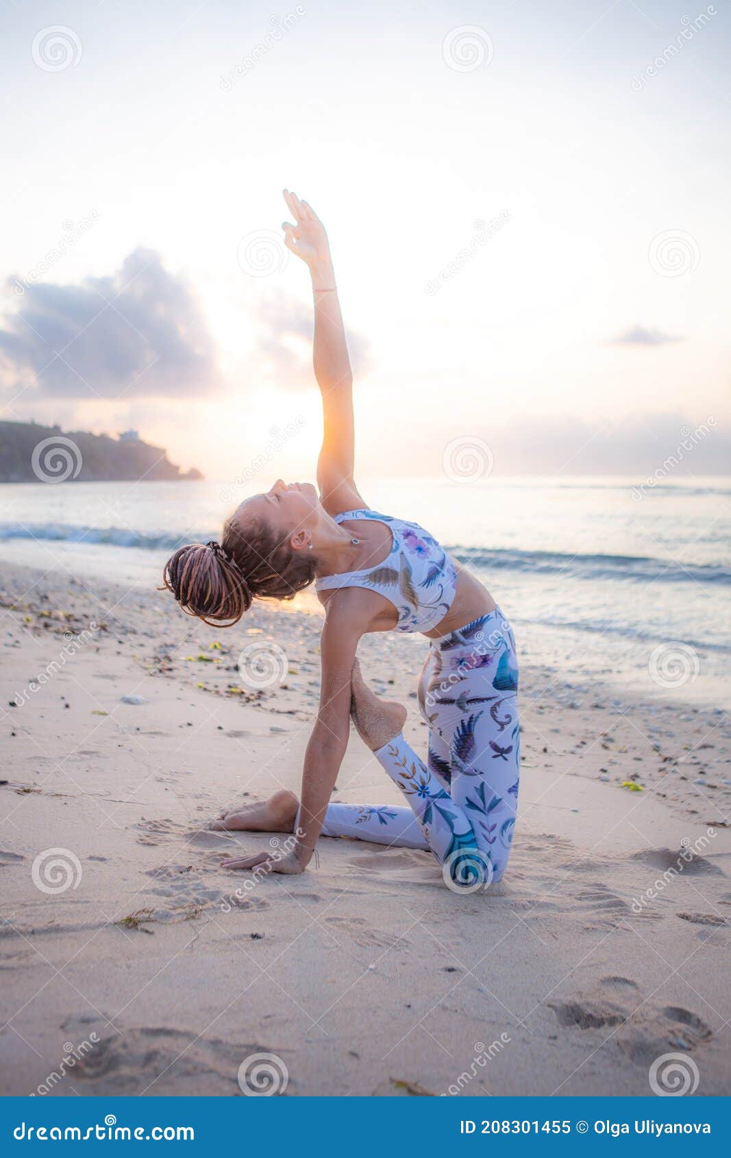 outdoor yoga on the beach. young woman practicing variation of ushtrasana  camel pose  kneeling back bending asana. flexible spine