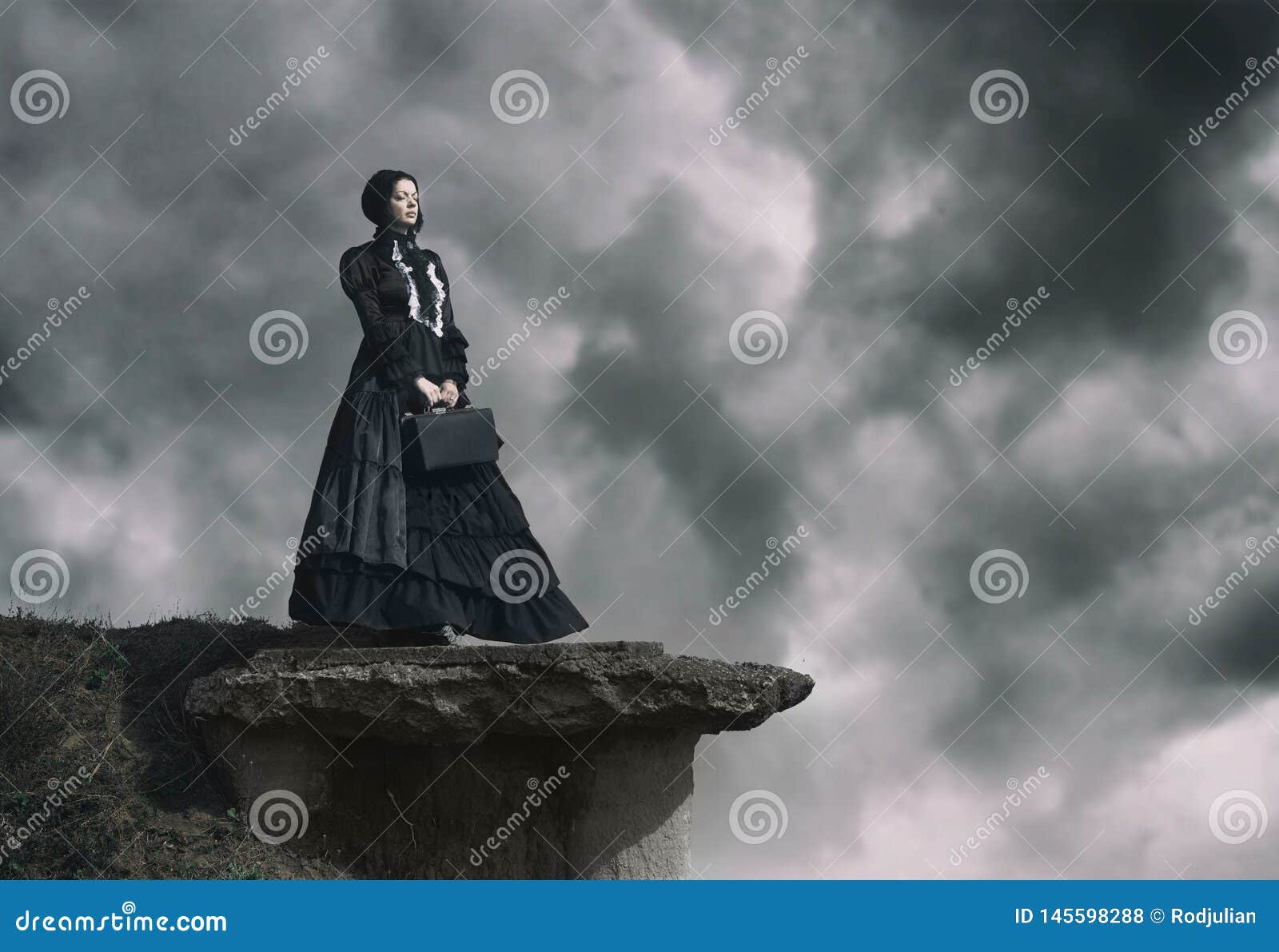 outdoors portrait of a victorian lady in black standing on the cliff