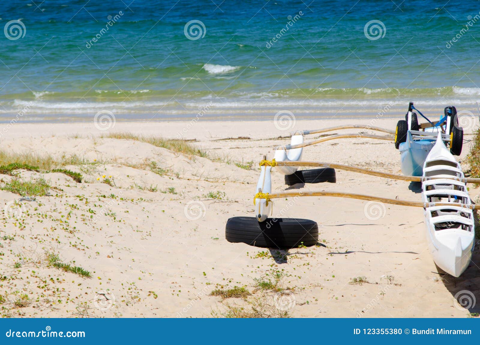 Outrigger Sailing Canoes on the Beach Near Blue Ocean Water at