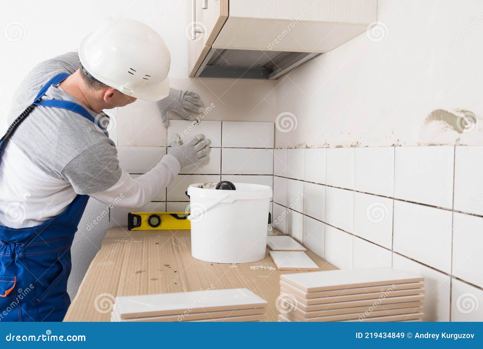 Ouvrier Met Des Tuiles Sur Le Mur Dans La Cuisine Finition Travaux Dans  L'appartement Image stock - Image du installation, concret: 219434849