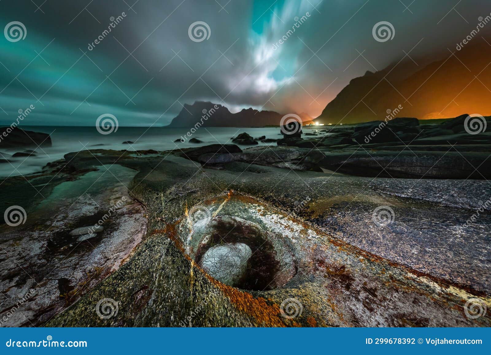 overcast sky lit by aurora borealis over the famous rock formation, dragon's eye