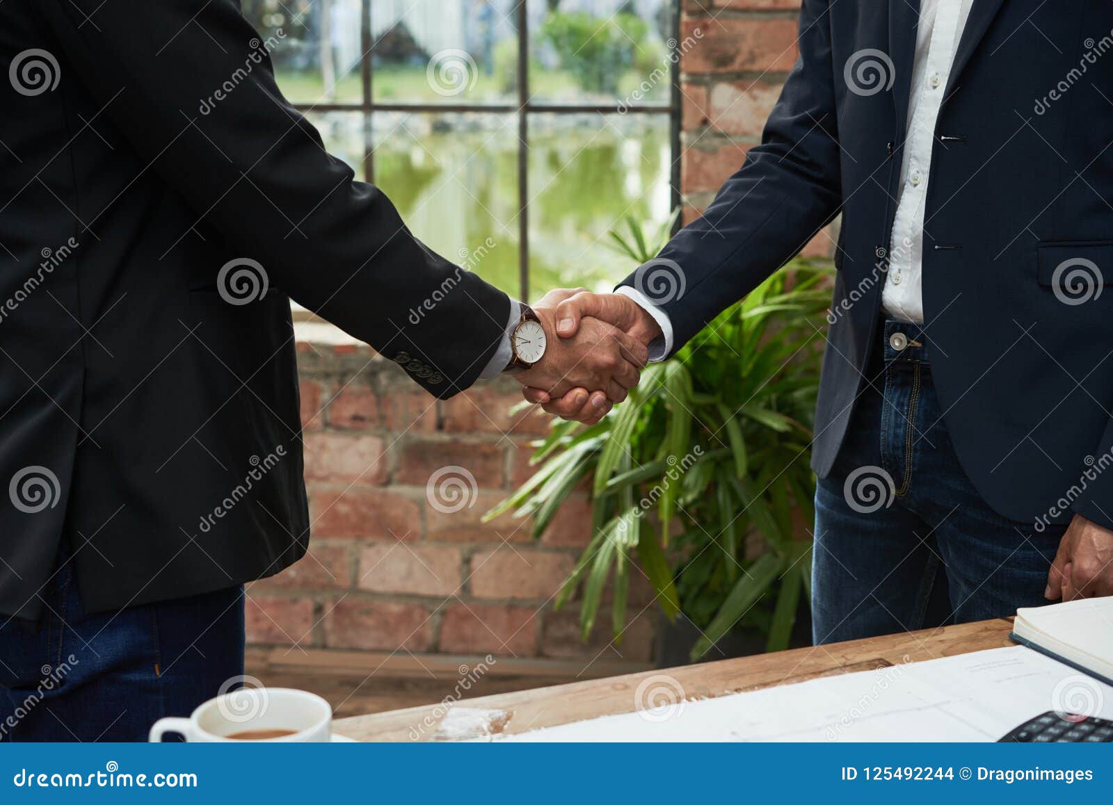 Bebouwd beeld van bedrijfscollega's die handen schudden om overeenkomst te bevestigen