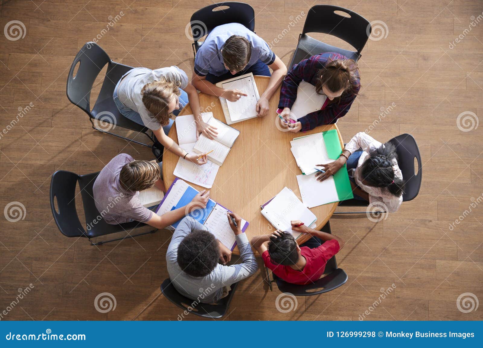 Overhead Shot of High School Pupils in Group Study Around Tables Stock