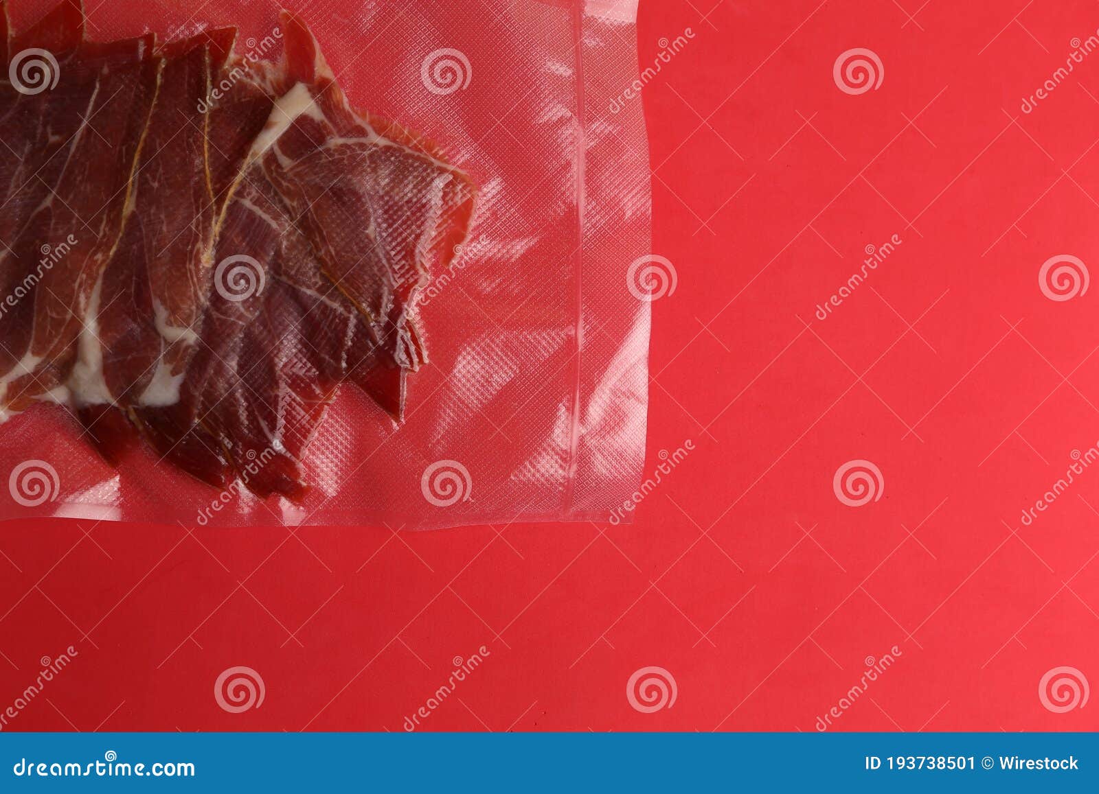 Overhead Shot of a Vacuumpacked Serrano Ham Isolated on a Red
