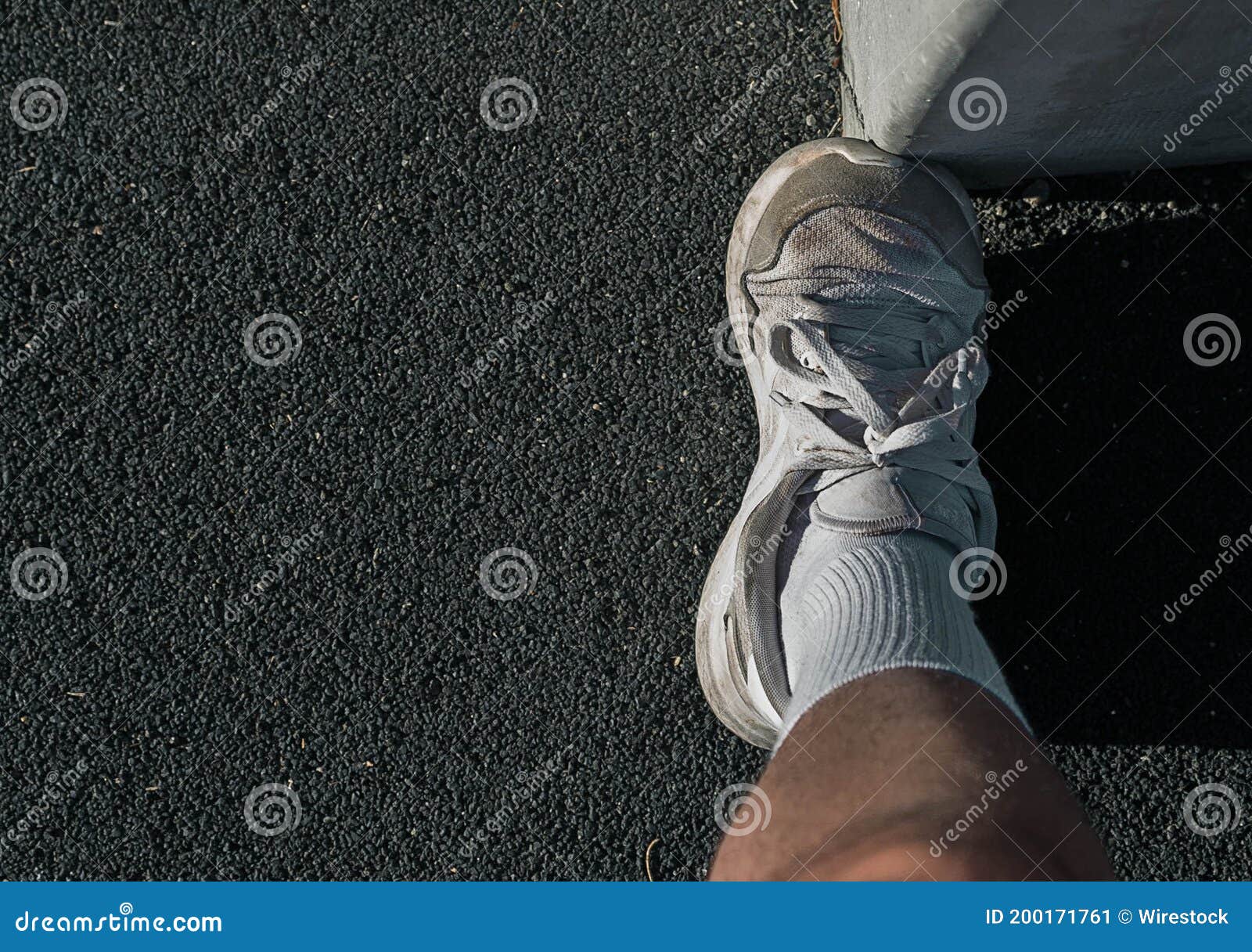 Overhead Shot of a White Rubber Shoe Pressed Against a Concrete Post ...