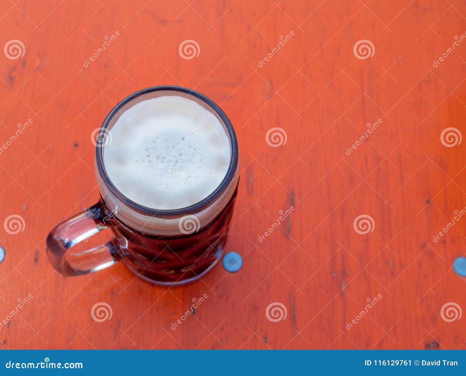 overhead view of foamy german beer mug on table