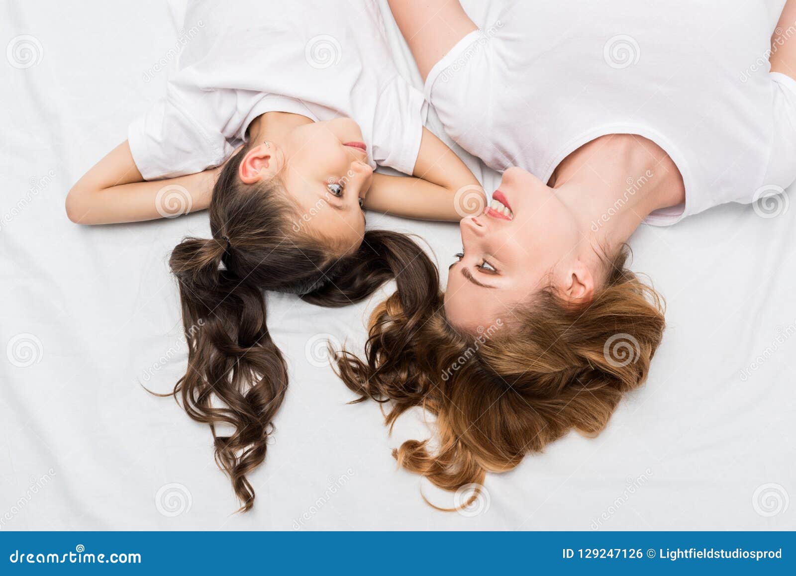 Overhead View Of Mother And Daughter Looking At Each Other While Lying