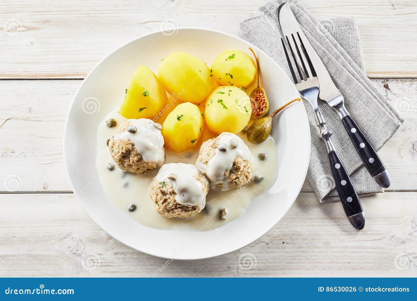 overhead view of potatoes and meatballs with sauce