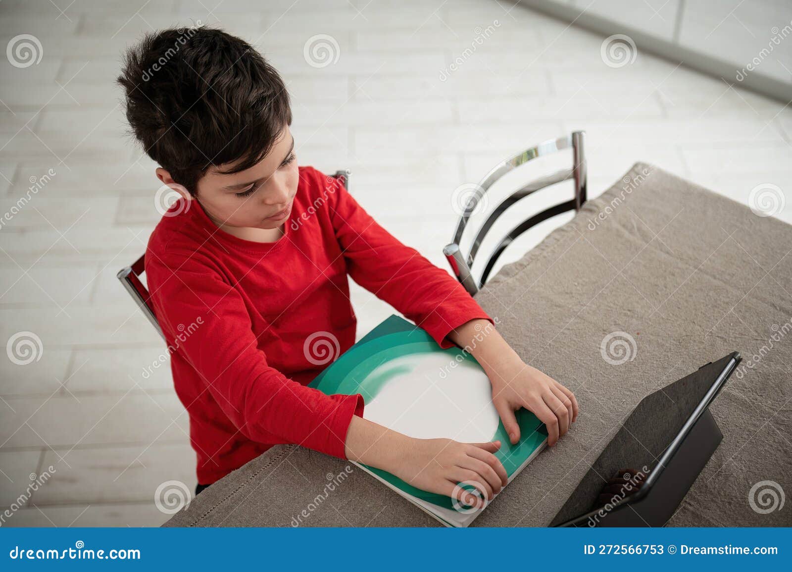 Overhead View of a School Child Doing Homework, Using Digital Tablet To