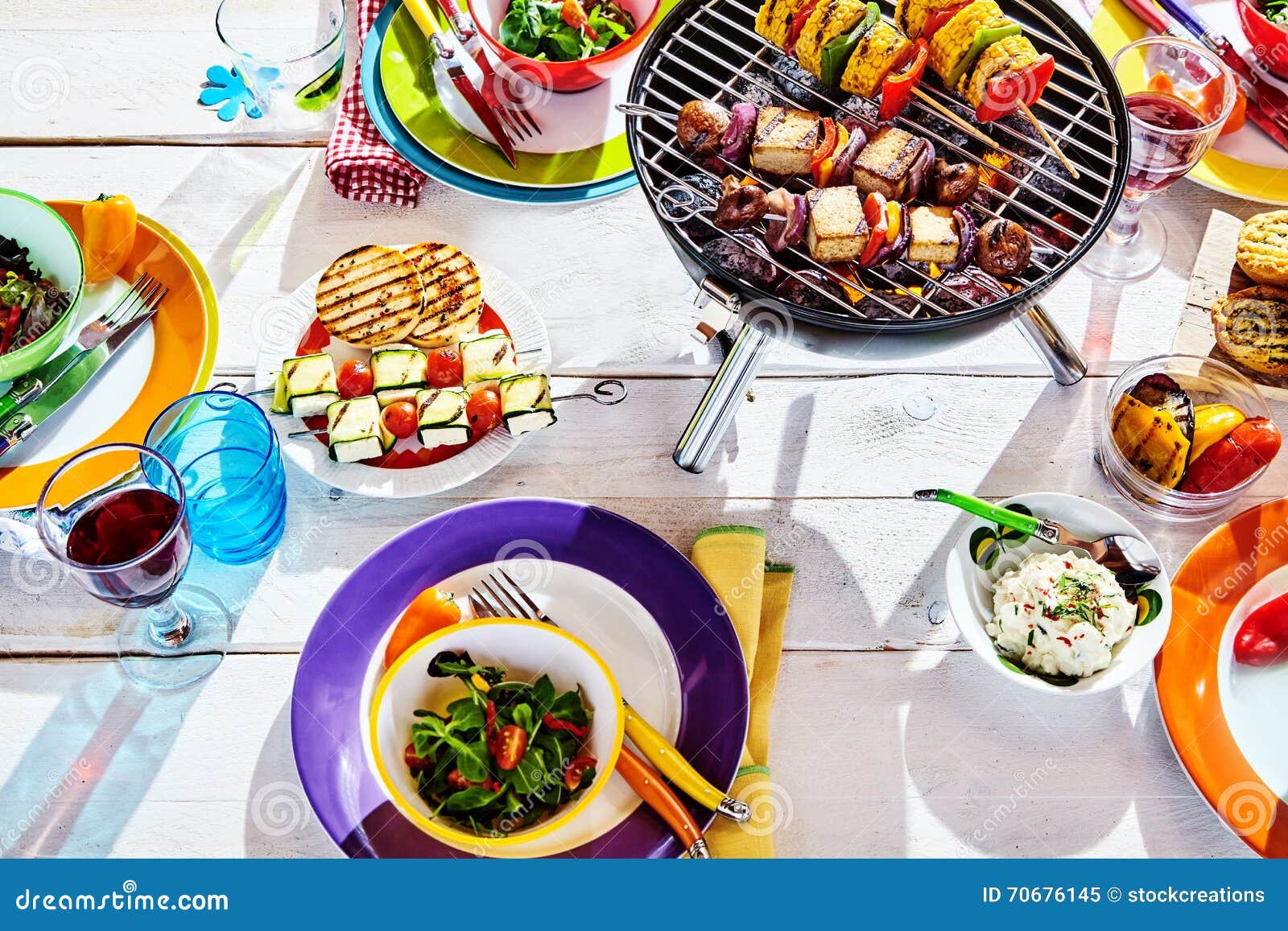 overhead well laid summer table with colorful dish and brazier