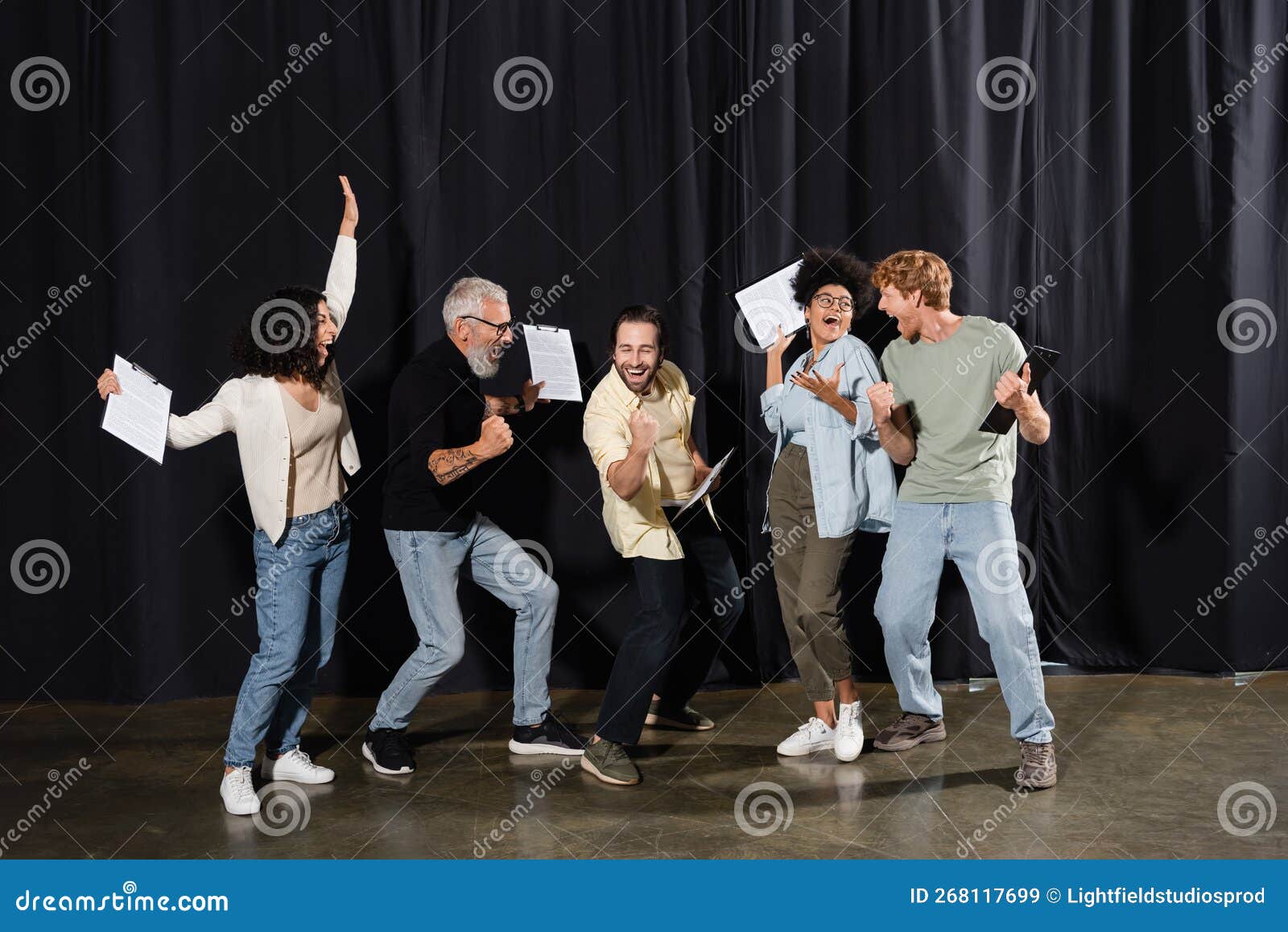 overjoyed multiracial theater troupe holding clipboards