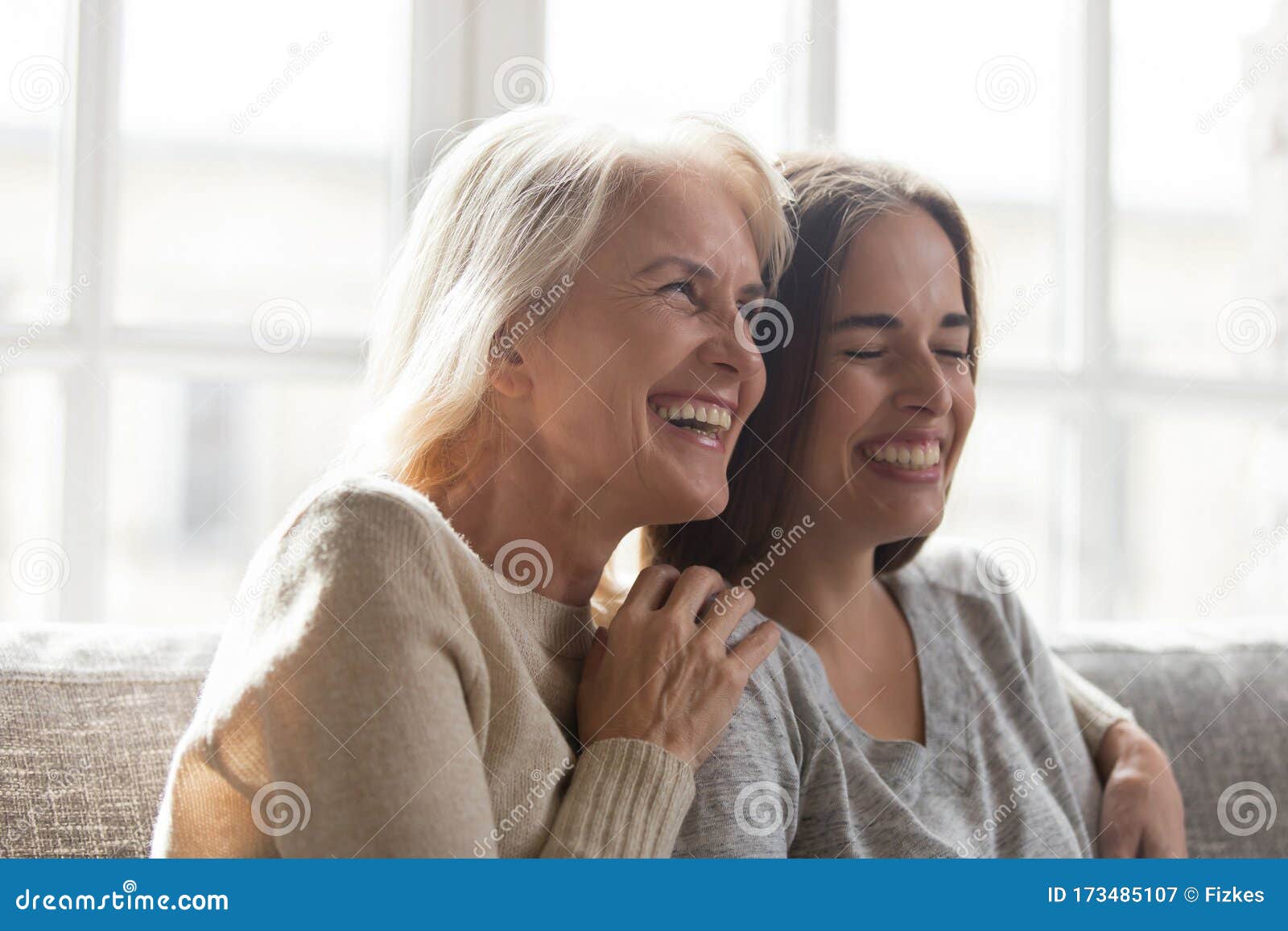 overjoyed senior mother hugging happy grown up adult daughter.