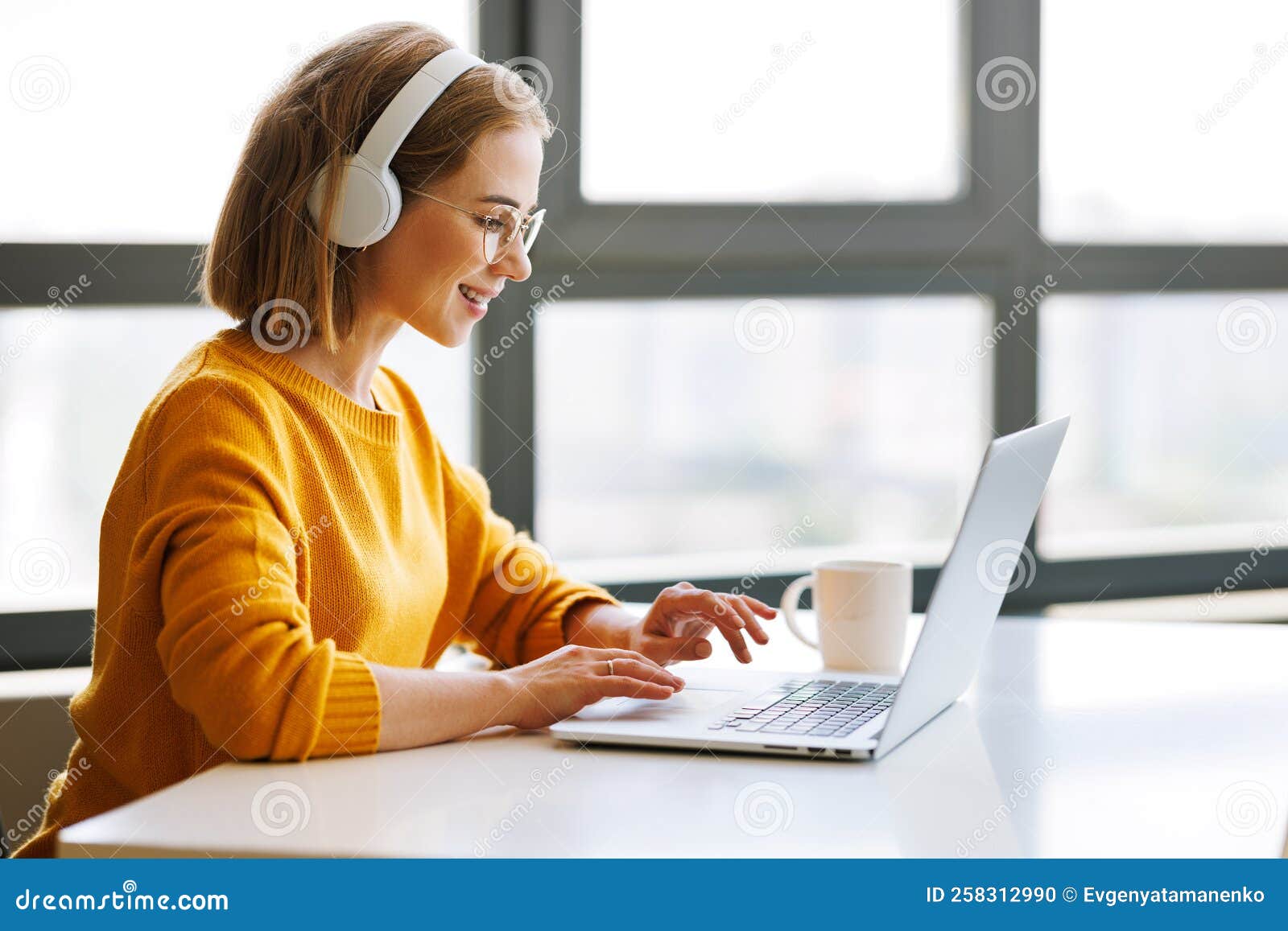 happy young female having video call while working remotely or studying online on laptop from home