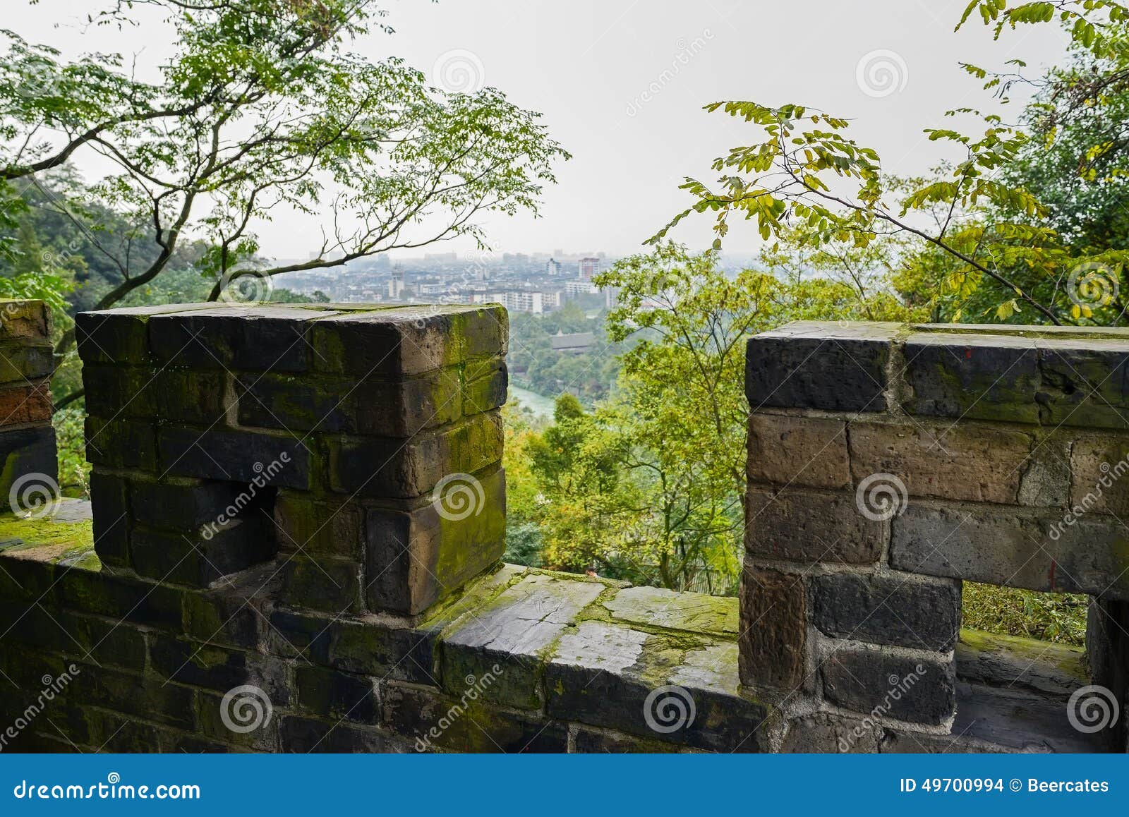 overlook to townsite from ancient lichen-covered parapet on mountaintop in afternoon