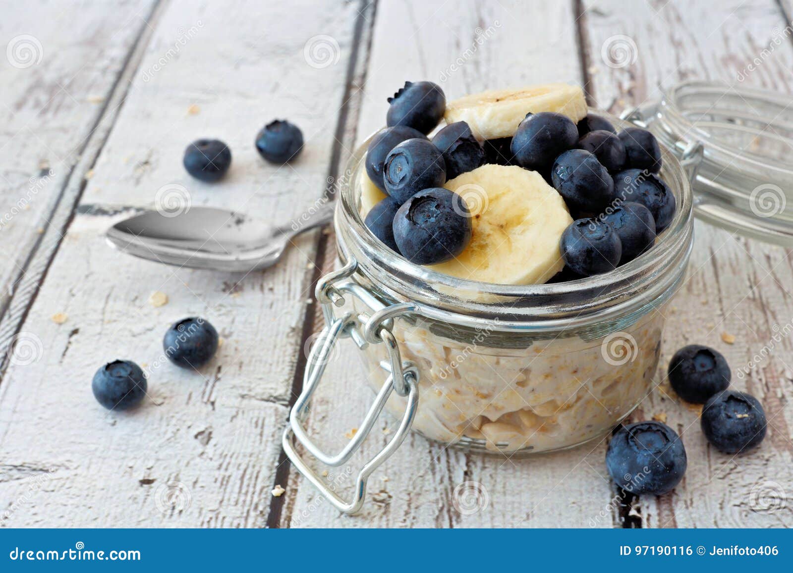 overnight oats with blueberries and bananas on a white wood background