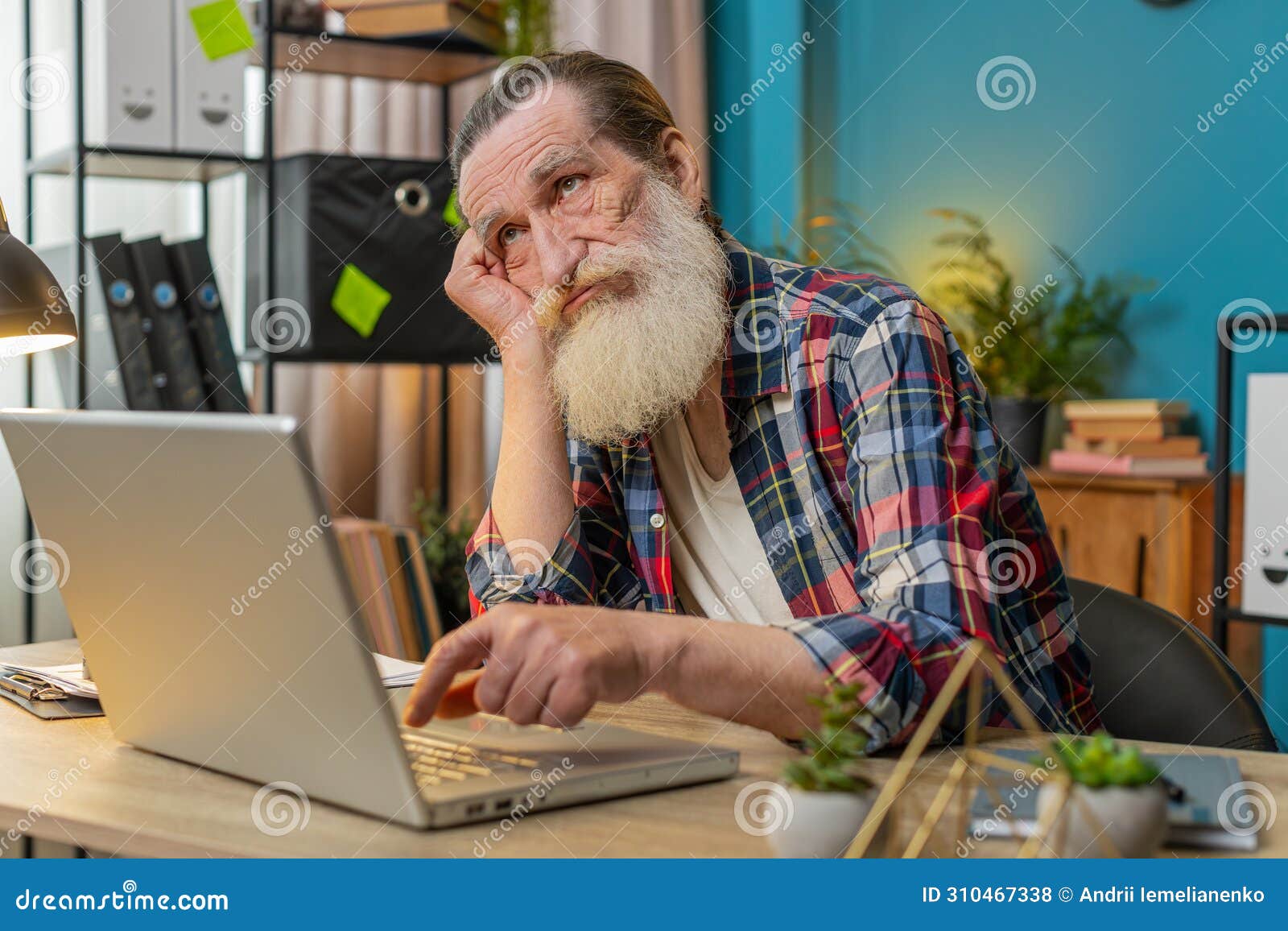 overtired sleepy lazy senior man grandfather bored working on laptop while sitting in home office