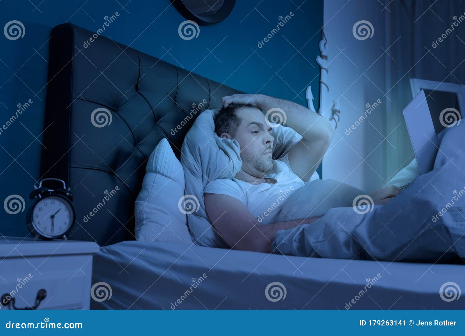 overtired man works on his laptop at late night