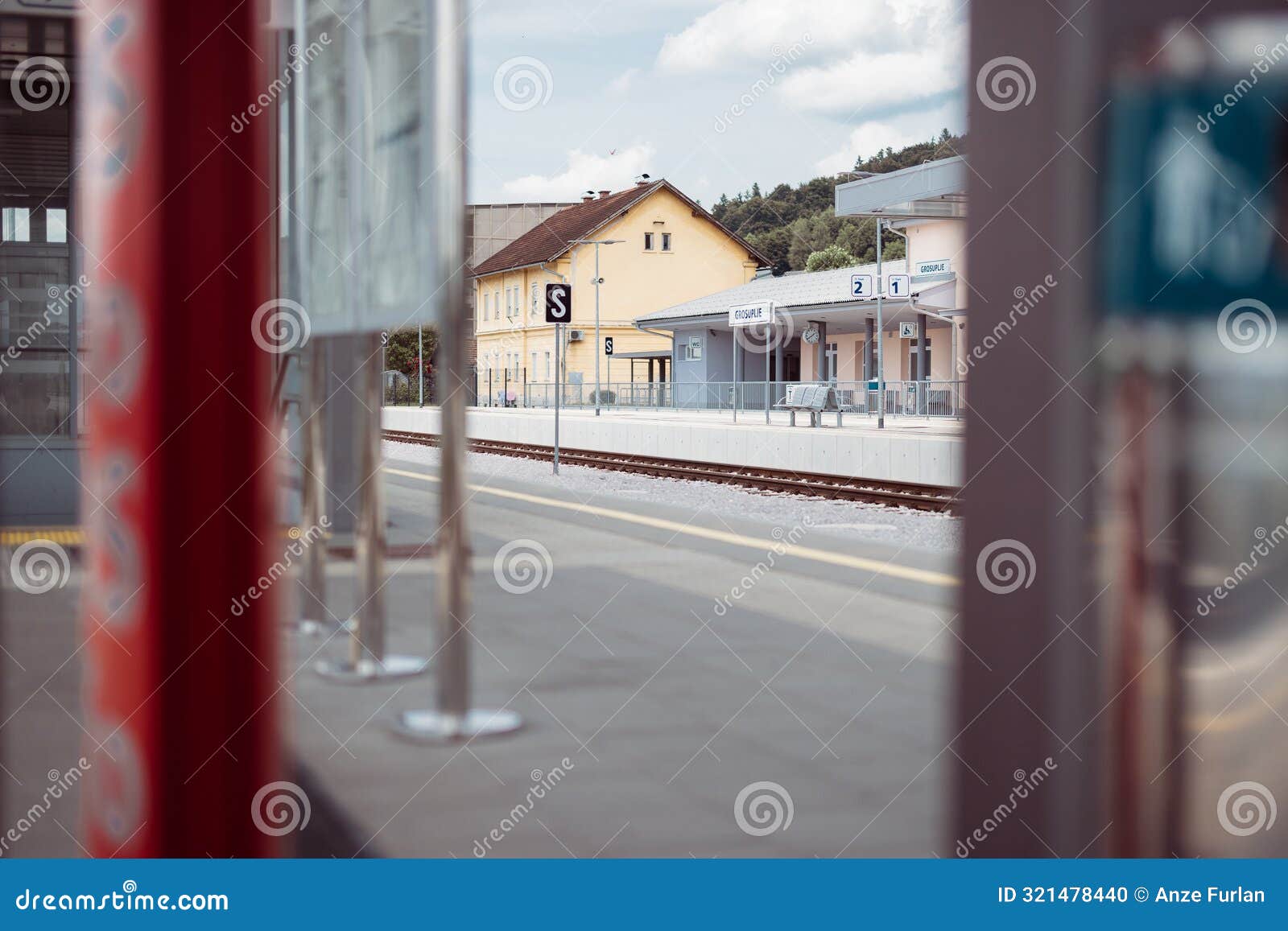 overview of grosuplje train station in slovenia. looking towards the main building from the second platform, visible boards for