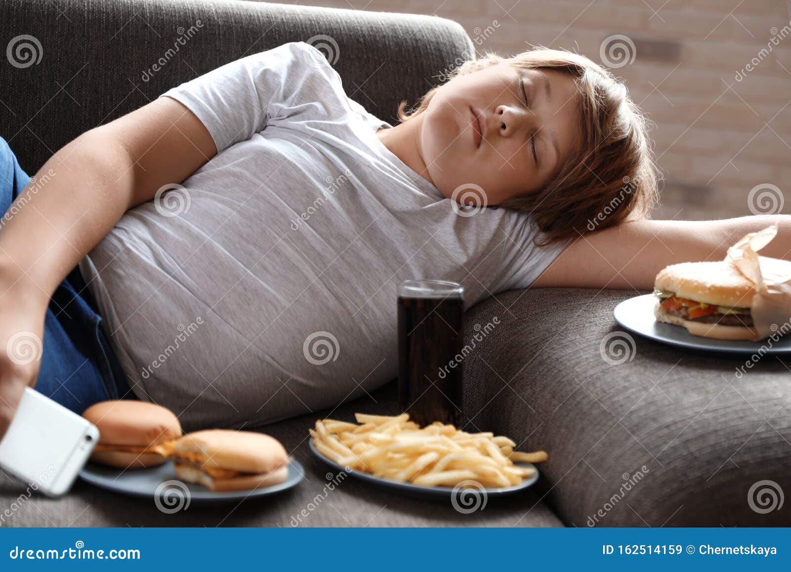 Overweight Boy on Sofa Surrounded by Fast Food Stock Image Image of