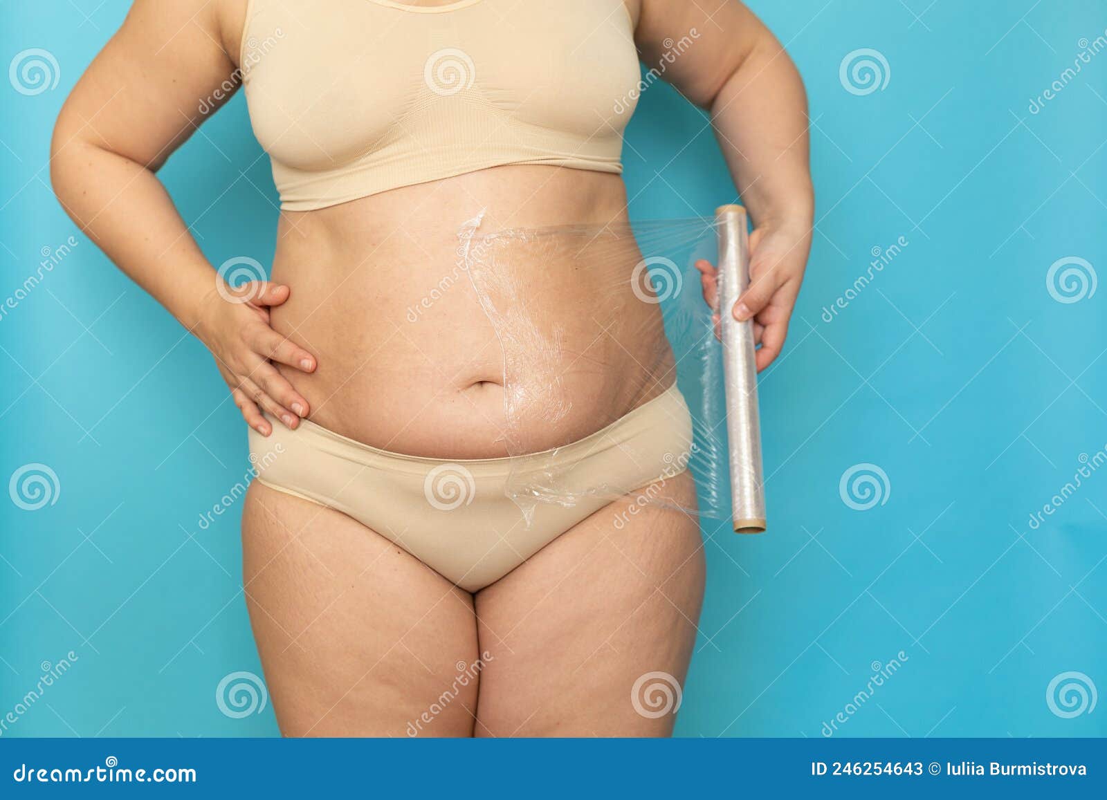 Premium Photo  Plus size woman in beige underclothes pulling shapewear  panties over belly closeup tighten figure and wear lifting underwear for  weight loss blue background concept of diet and fighting overweight