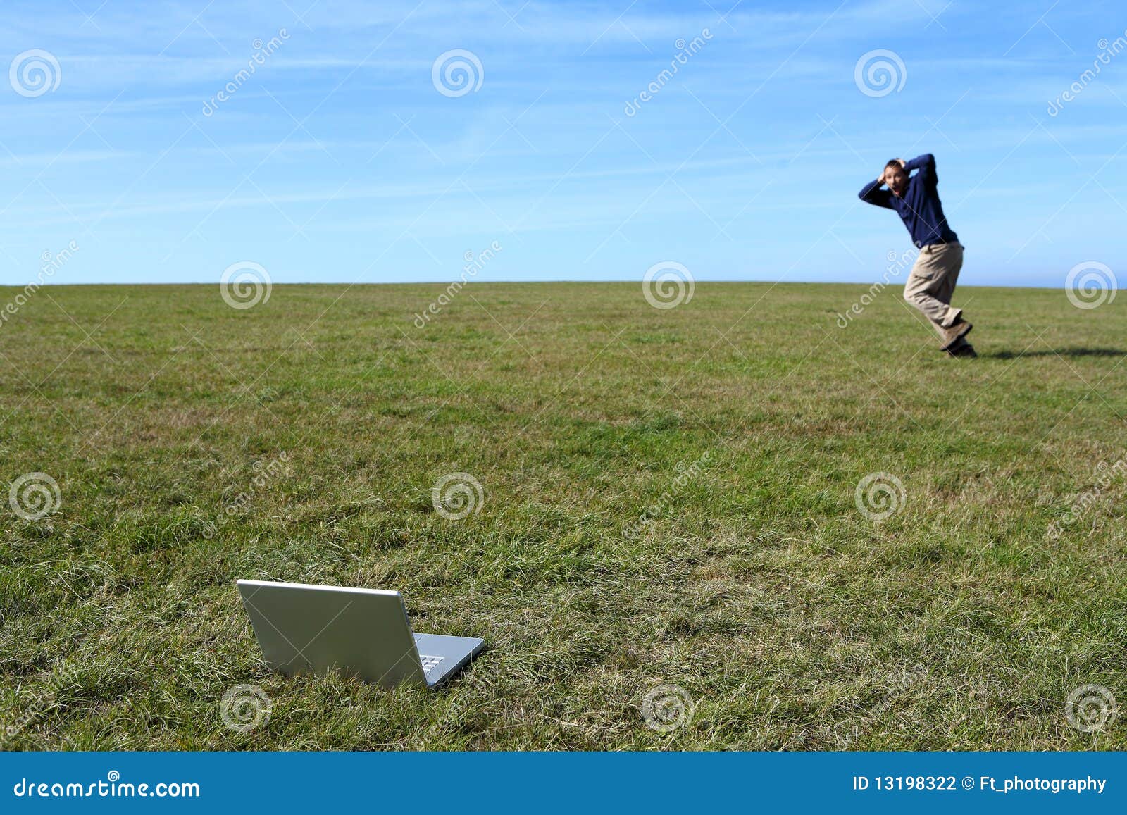 overwhelmed man running in field away from laptop