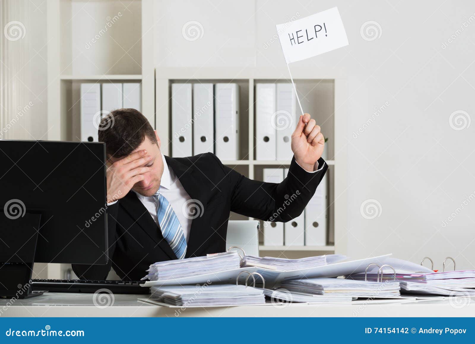 overworked accountant holding help sign at desk