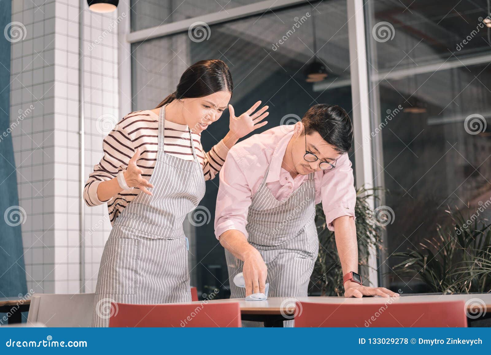 owner of cafeteria feeling unsatisfied checking the cleanness of table