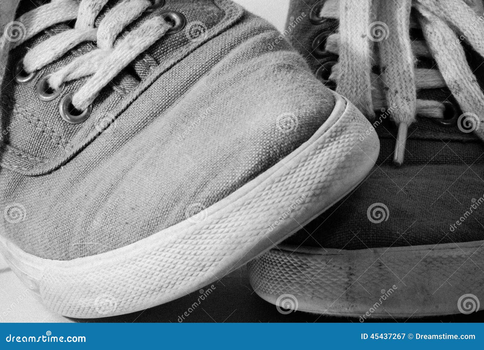 Paare Schuhe kreuzten in B und in W. Ein Paar schmutzige Schuhe und Füße kreuzte in Schwarzweiss