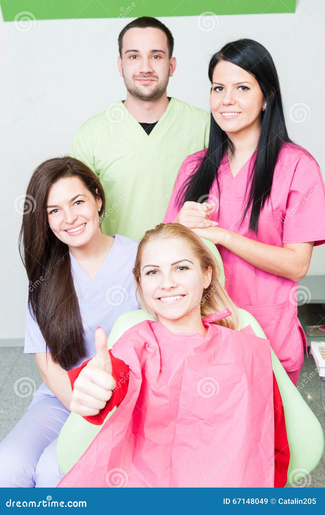 Paciente feliz e equipe dental no escritório do dentista