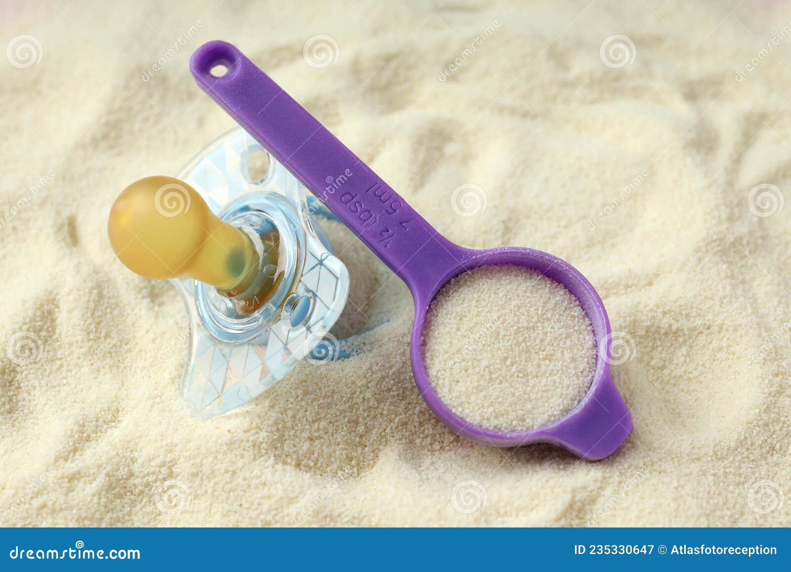 Pacifier and Measuring Spoon on Powdered Milk Background Stock Image