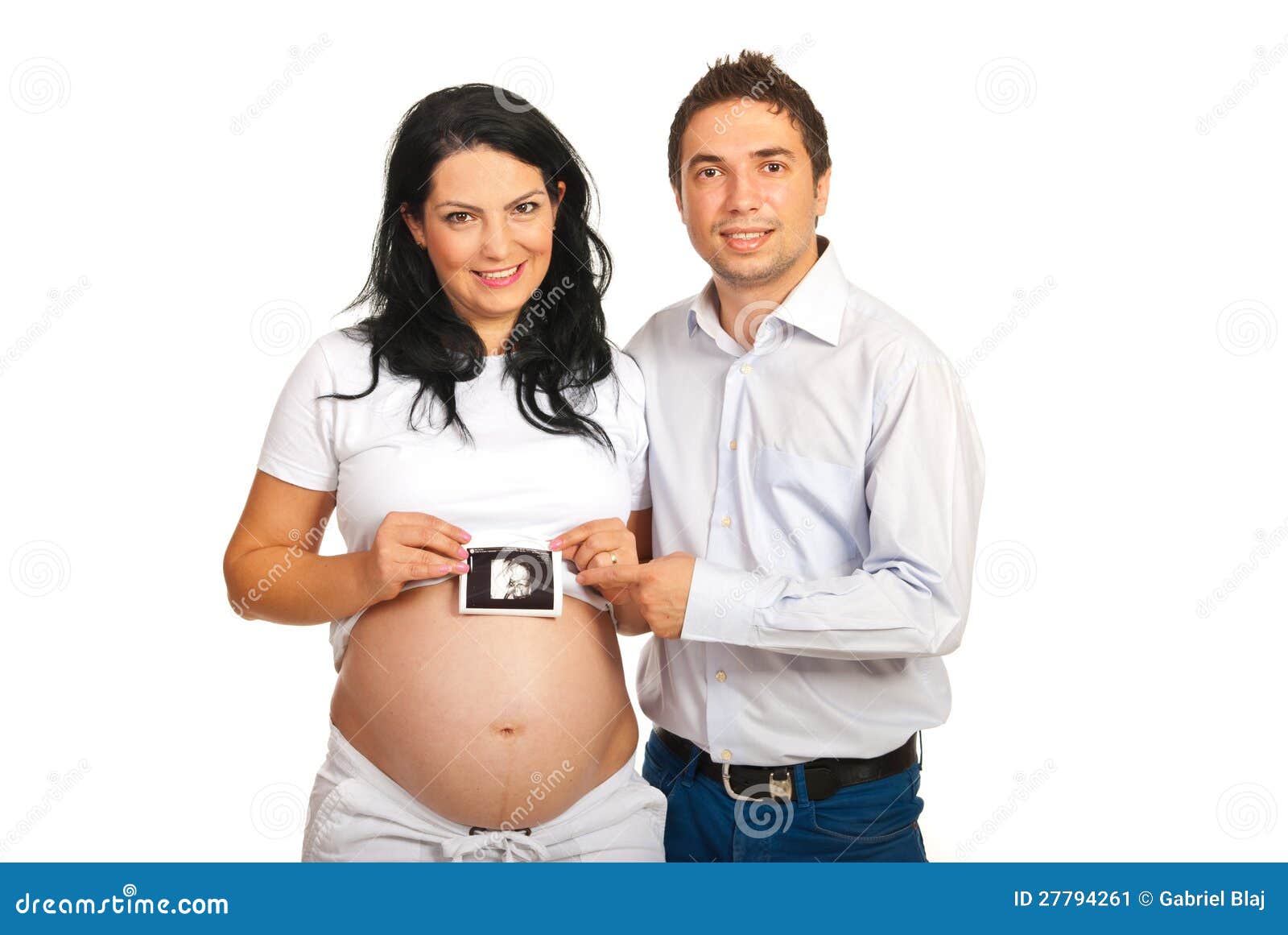 Padres felices que llevan a cabo sonogram del bebé. El futuro feliz parents el sonogram del bebé de la explotación agrícola aislado en el fondo blanco