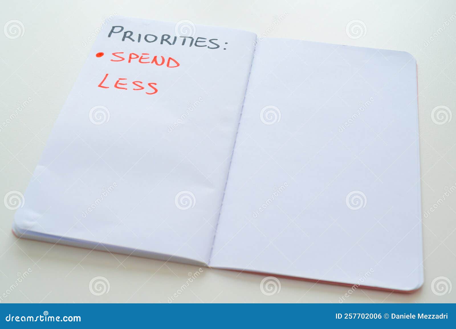 notebook page, with text `priorities: spend less`