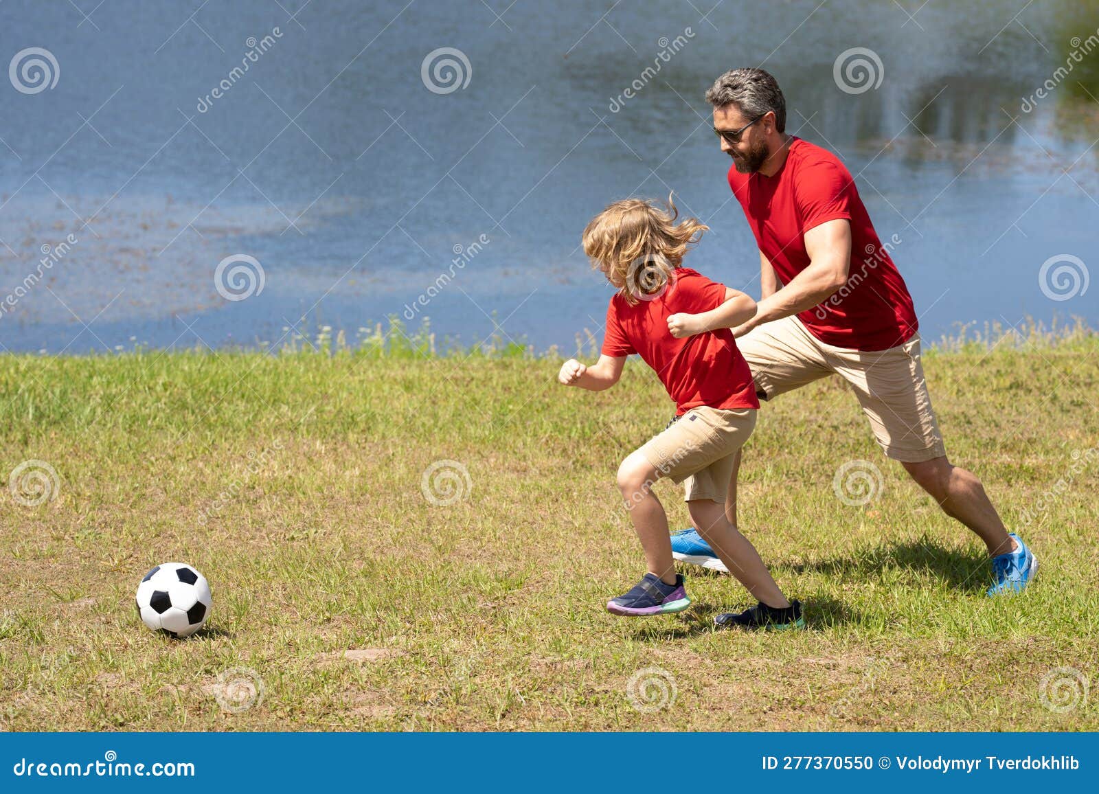 Perto da bola de futebol no campo verde  os jogadores vão jogar juntos
