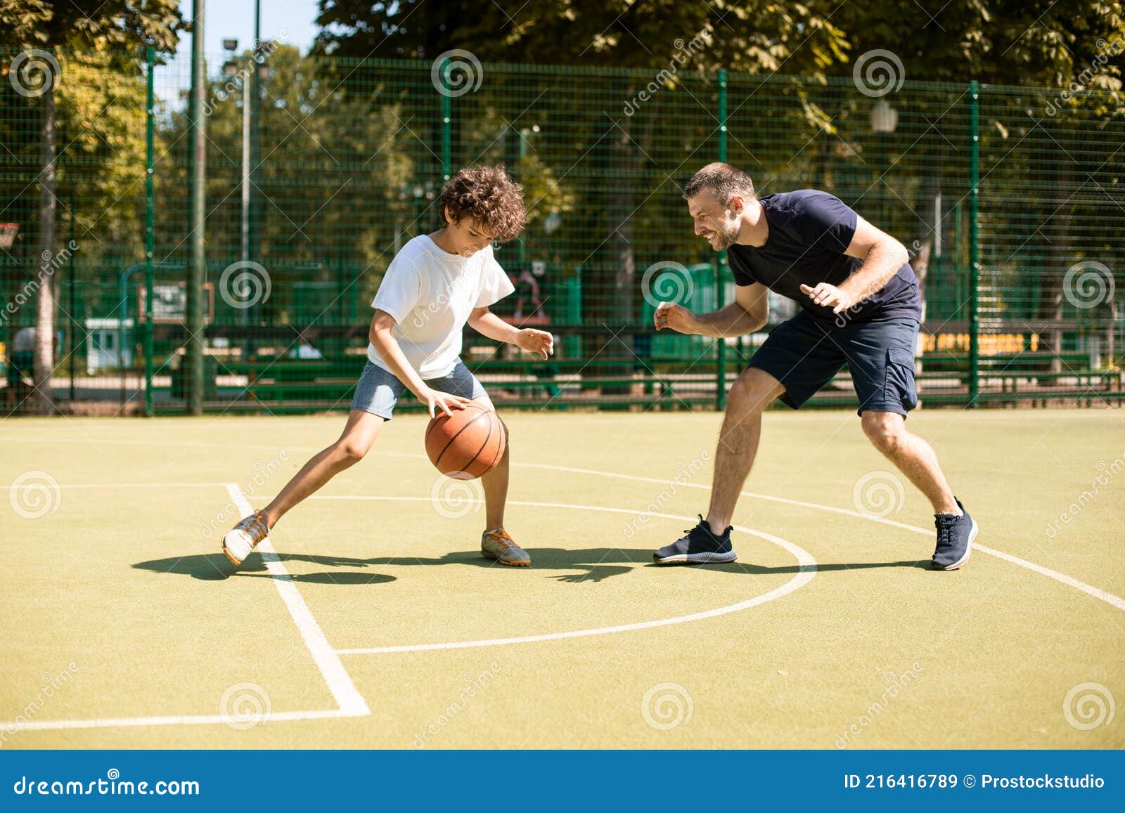 Esportivo Ensinando Garoto a Jogar Basquete Lá Fora Foto de Stock - Imagem  de atividade, objetivo: 216416036