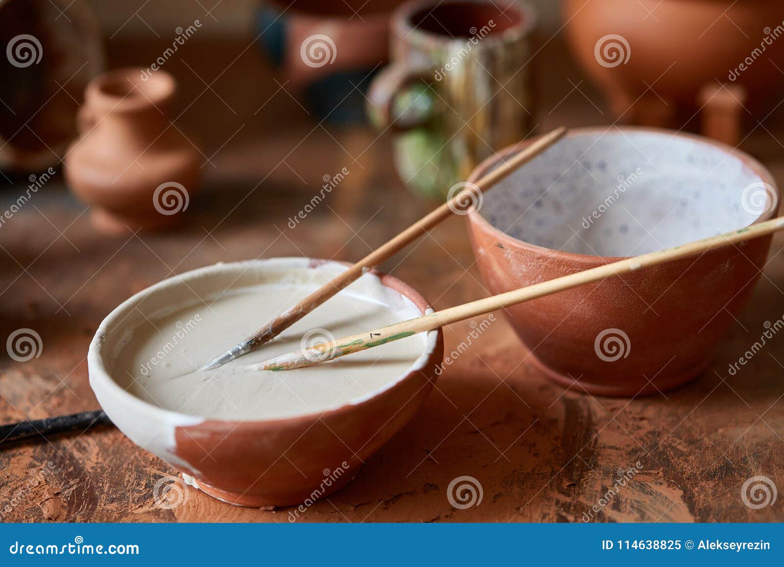 Paint Brushes Dip in Ceramic Bowl on Worktop in a Potter Closeup, Selective Focus