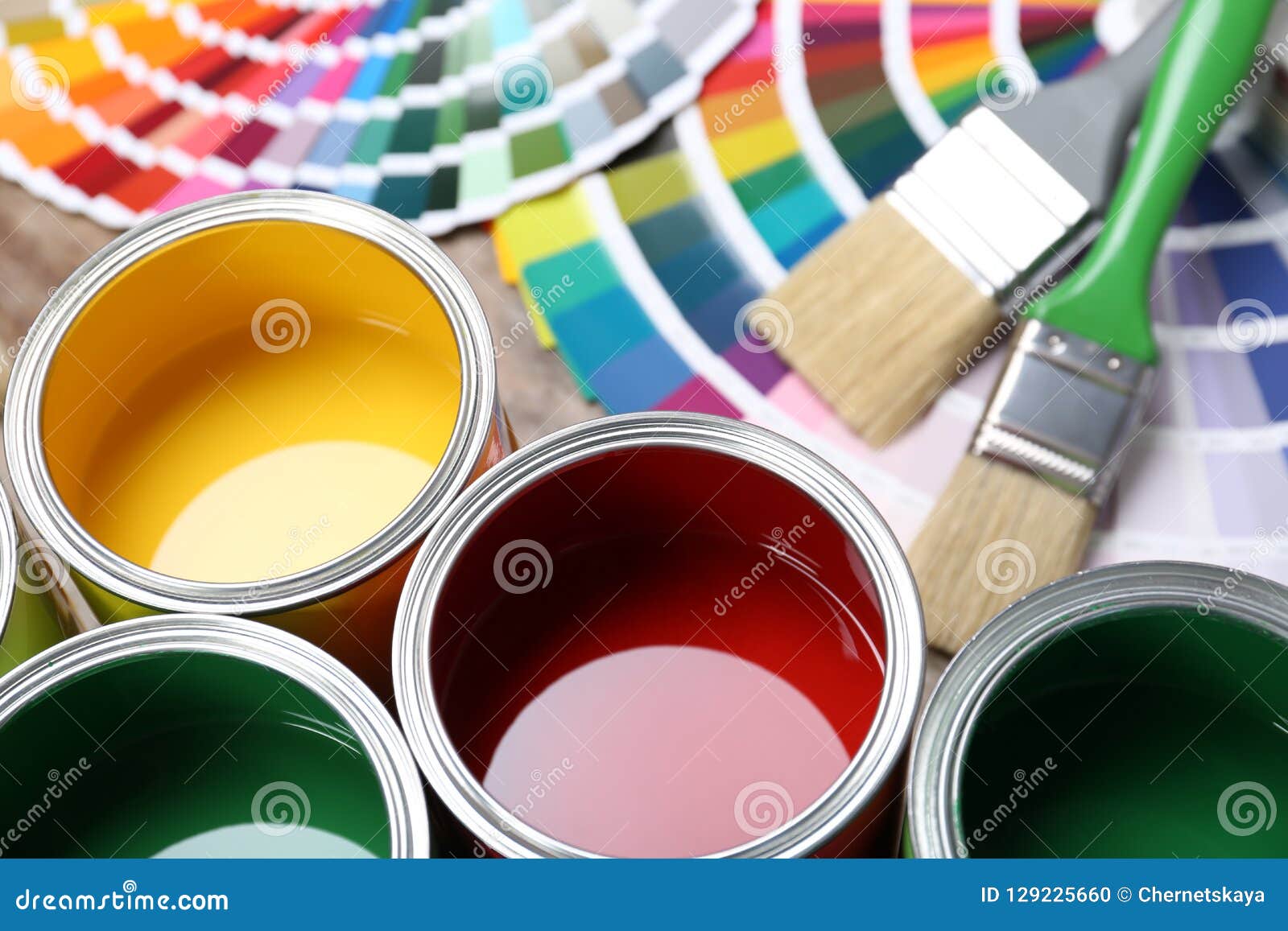 paint cans, color palette samples and brushes on table