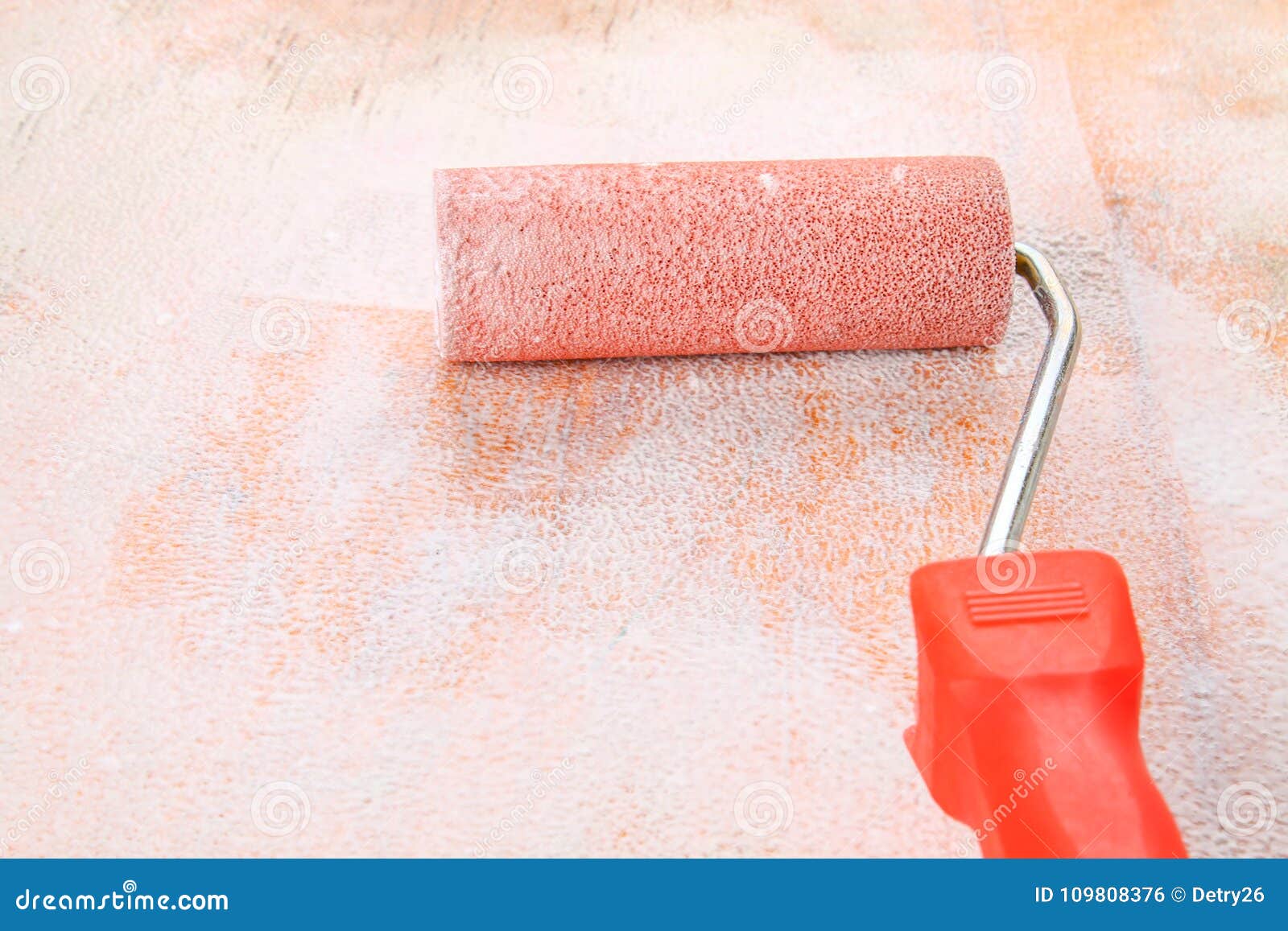 Paint Roll Brush in White Paint on Plywood Surface. Stock Photo Image